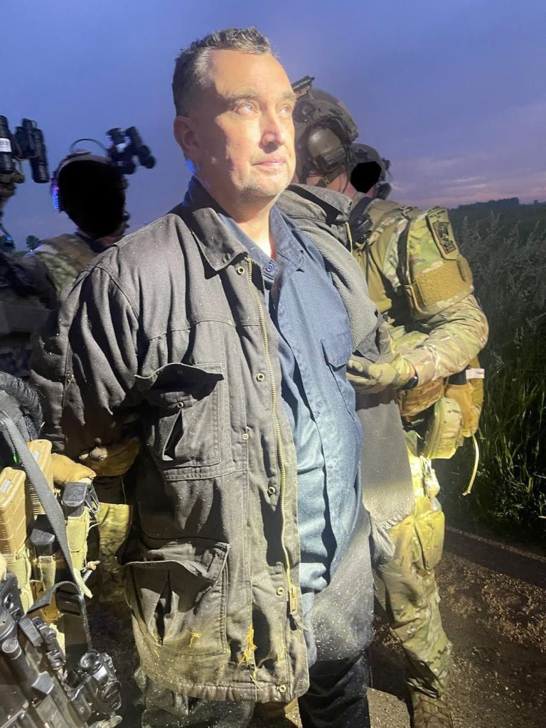 Boelter is detained by law enforcement agents after he was captured during a manhunt in Minnesota.