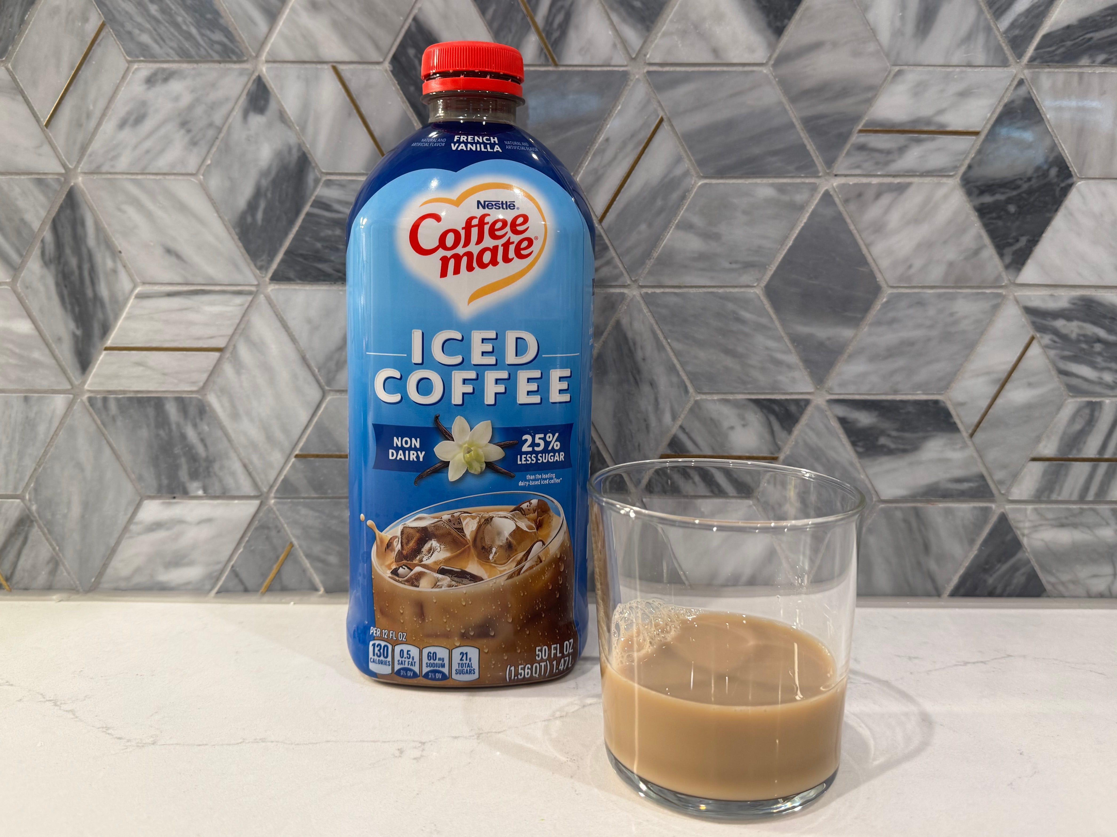 Coffeemate vanilla iced coffee bottle next to glass of iced coffee