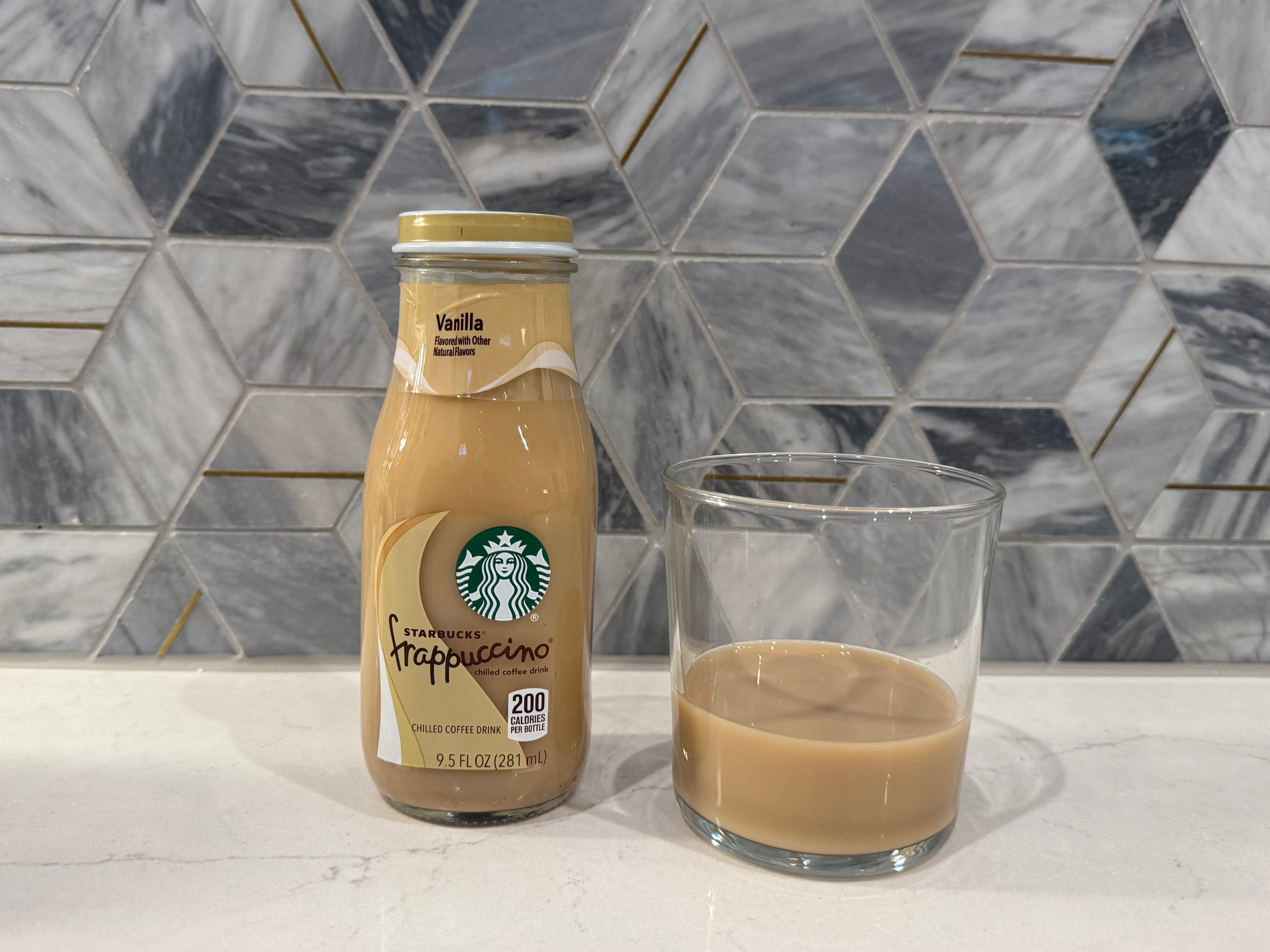 Starbucks vanilla iced coffee bottle next to glass of iced coffee