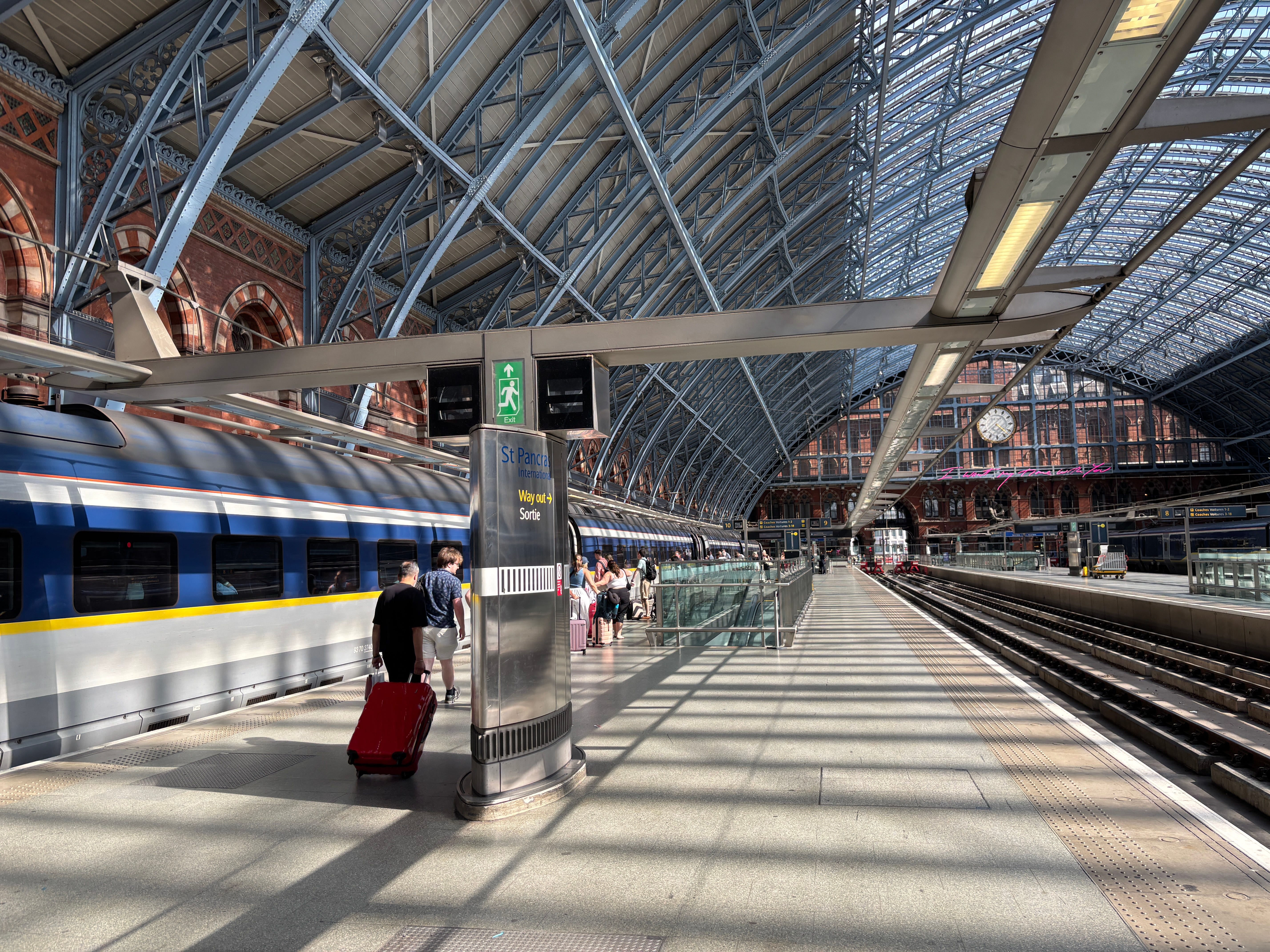 People walk towards a Eurostar train parked at the platform at London St. Pancras Station
