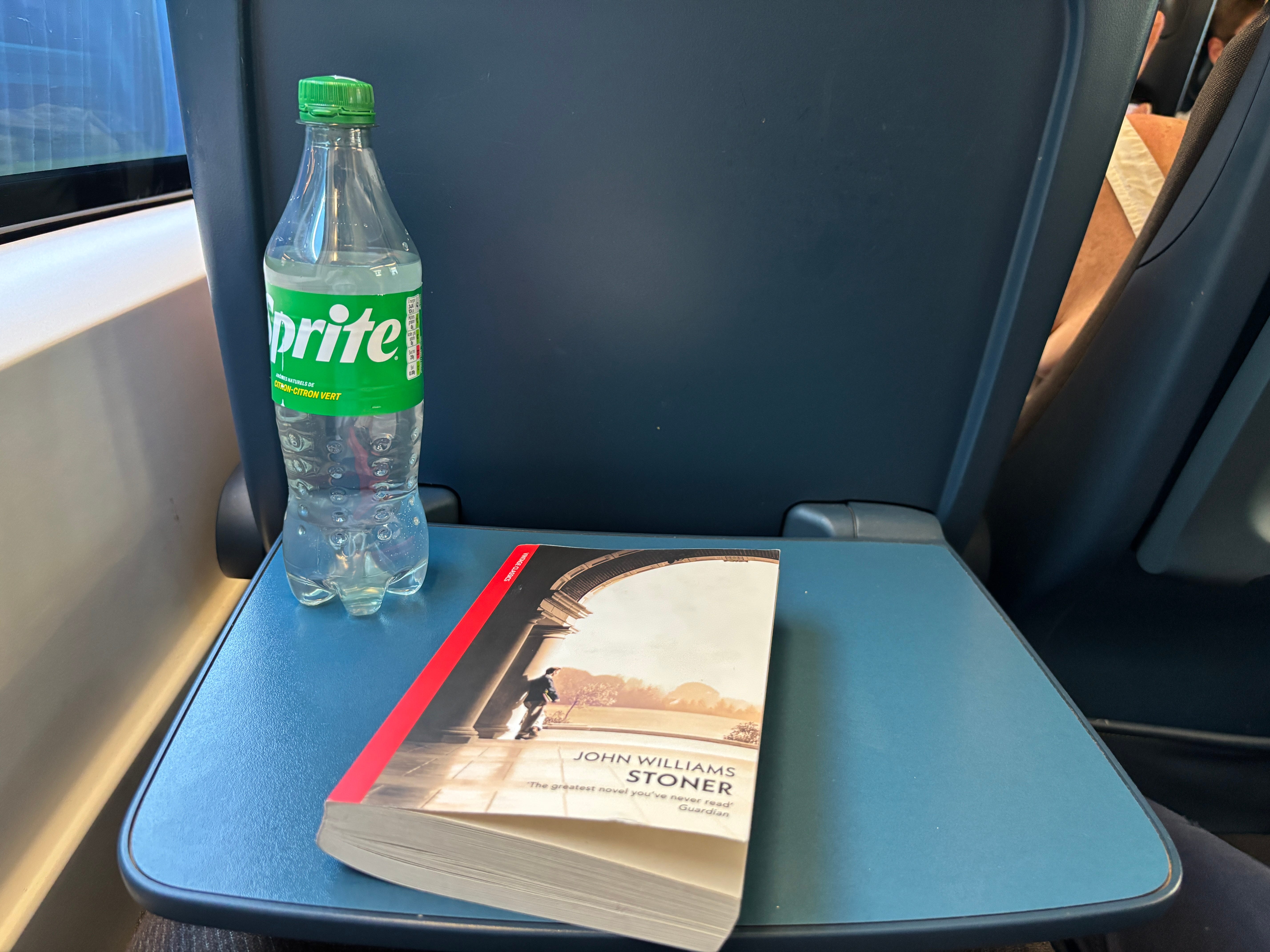 A novel and a soda on the seatback table of a typical Eurostar seat