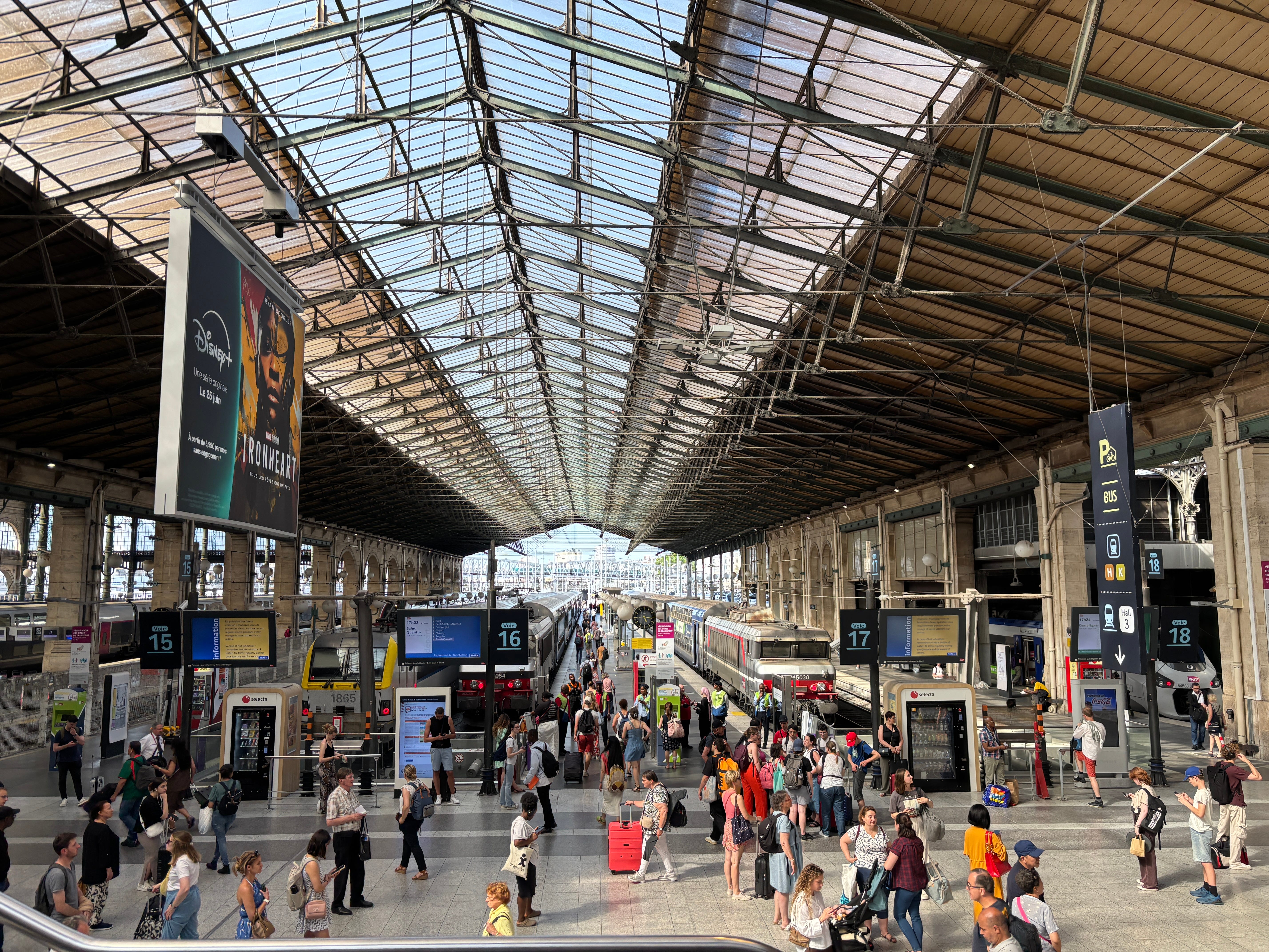 Crowds of people with suitcases and rucksacks walk through Paris's Gare du Nord as viewed from the escalators going towards the Hall 2 Eurostar entrance,