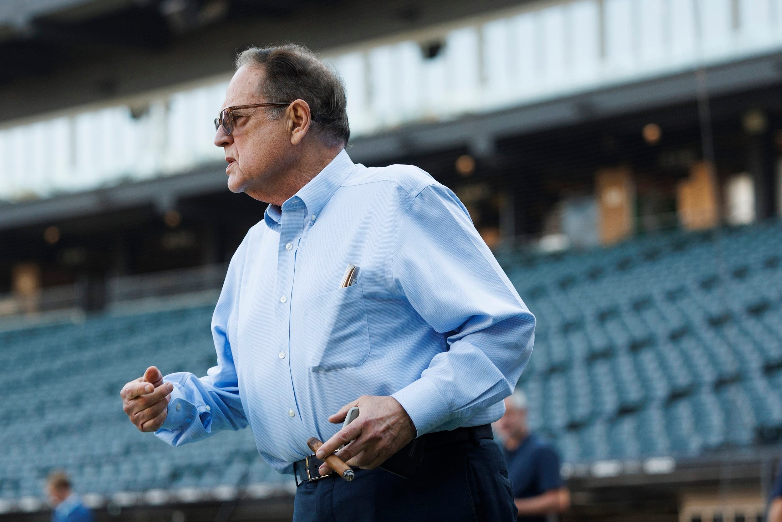 Jerry Reinsdorf smokes a cigar during warmups