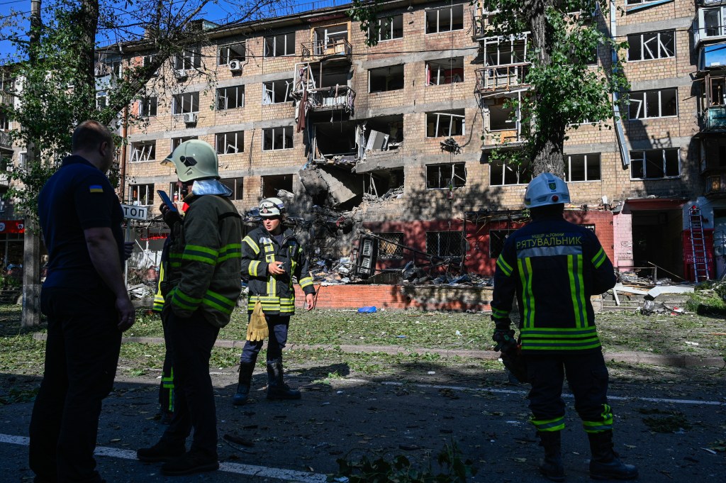 Firefighters surveying damage to a residential building in Kyiv after a Russian missile strike.