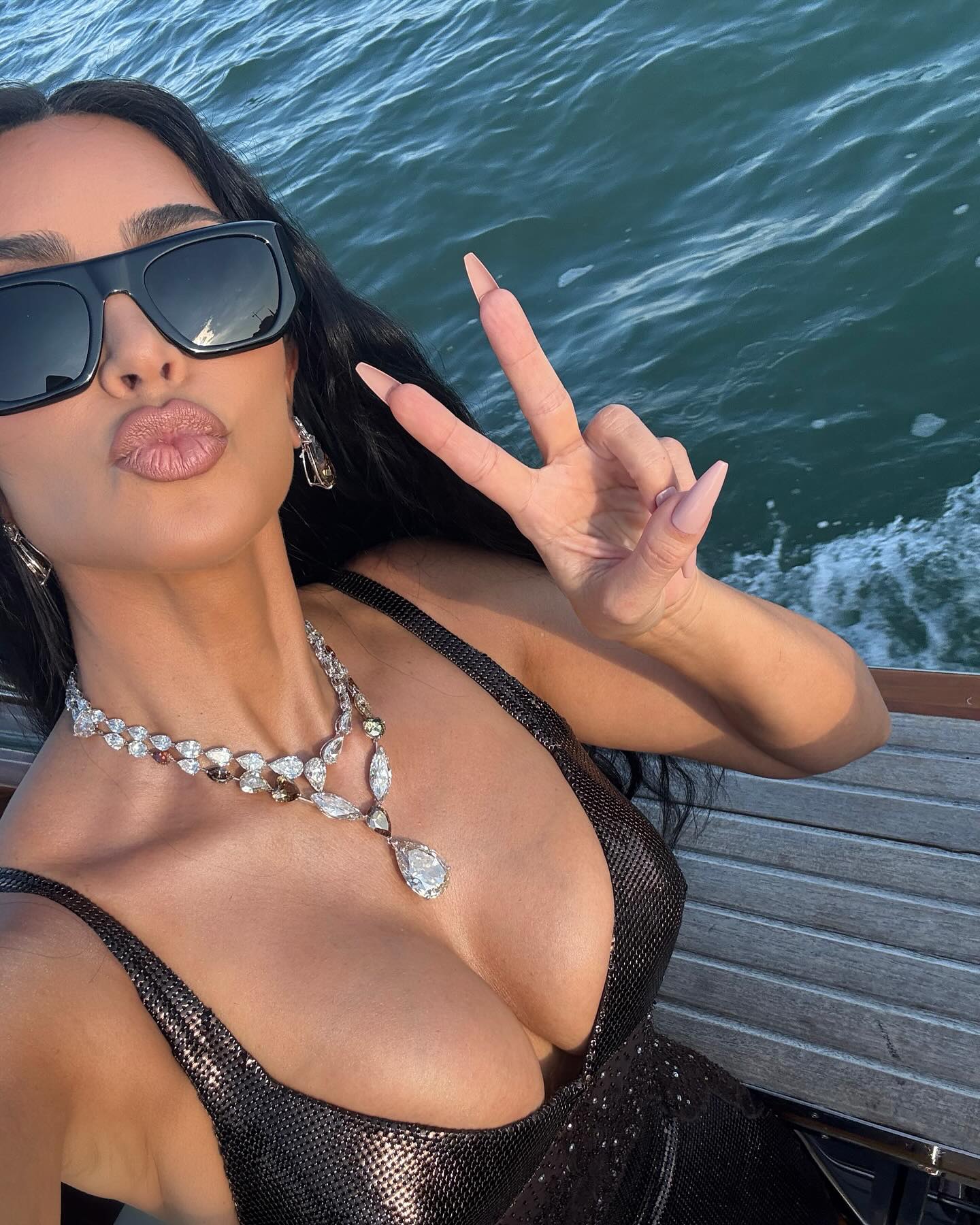 Kim Kardashian wearing a brown sparkly gown and diamond necklaces with sunglasses