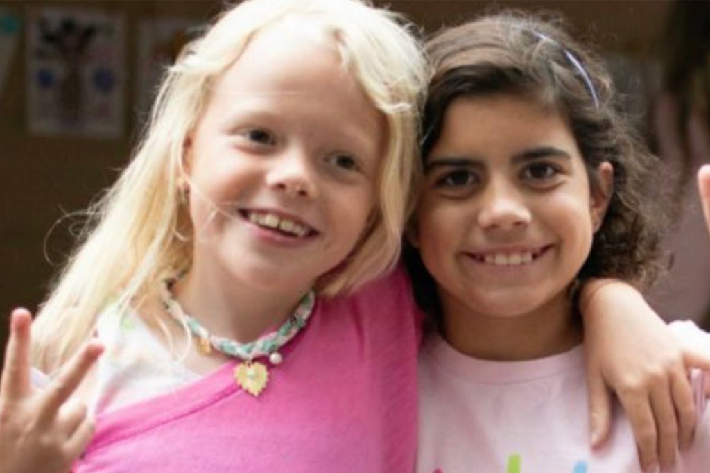 Two girls smiling and hugging.