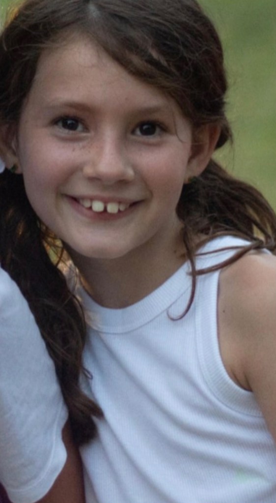 Photo of a girl in a white tank top.