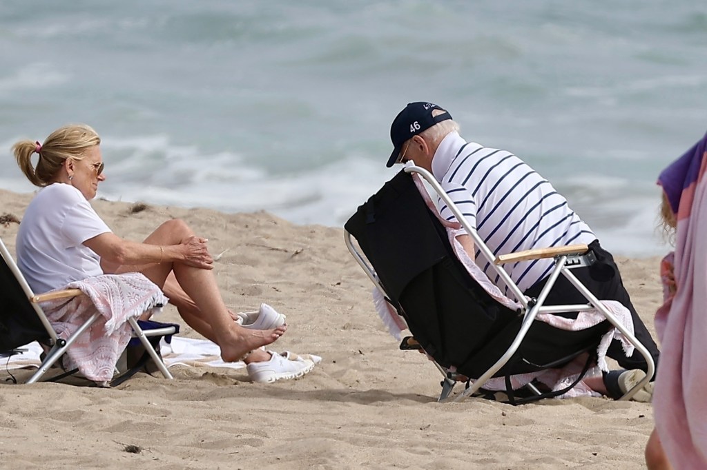 Joe Biden and a woman sitting in beach chairs on Malibu beach.