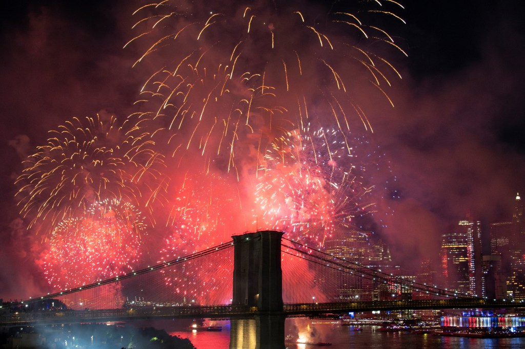 Fireworks over the Brooklyn Bridge and New York City skyline.