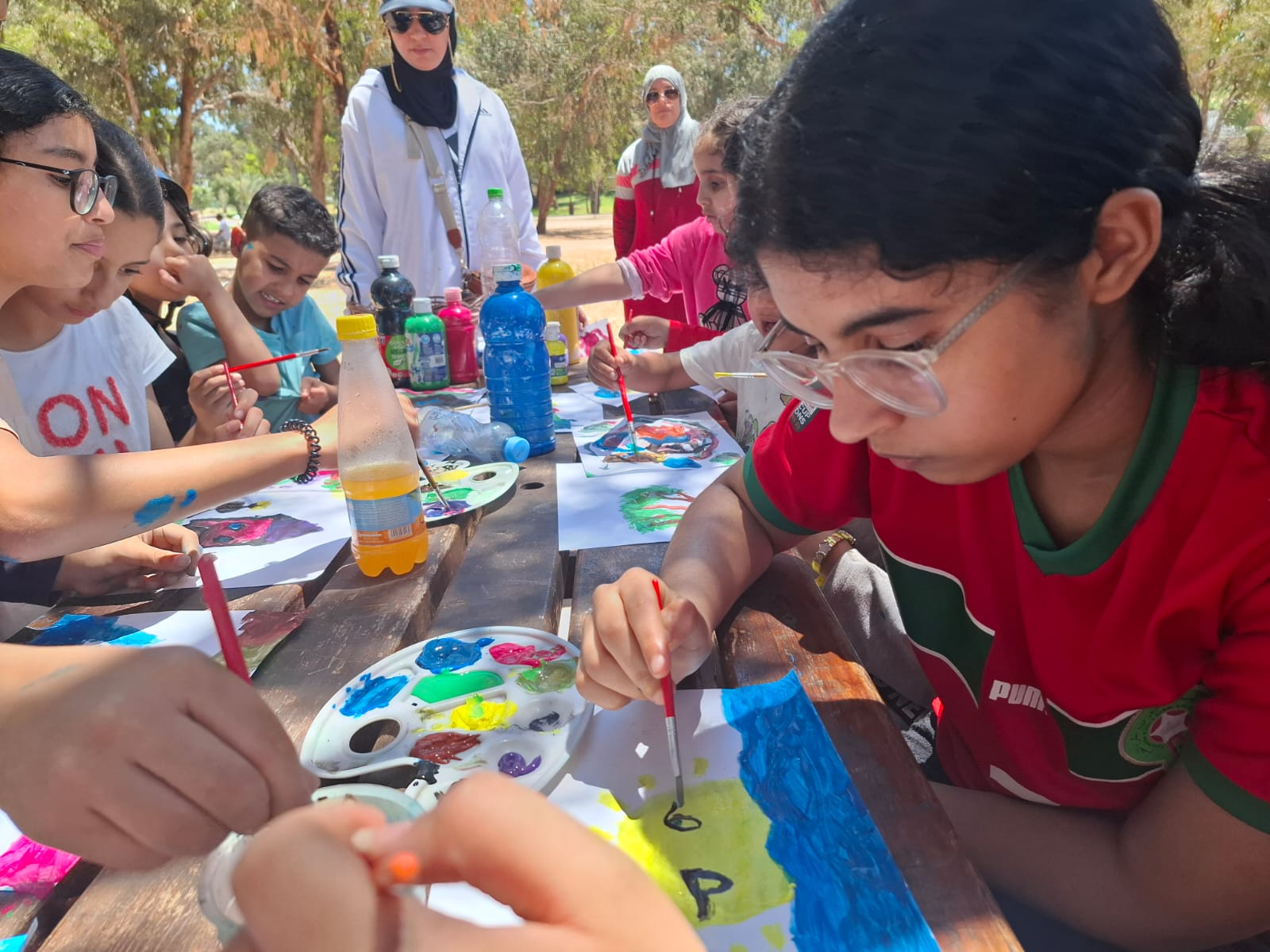 Students painting outdoors at Wilburn's school