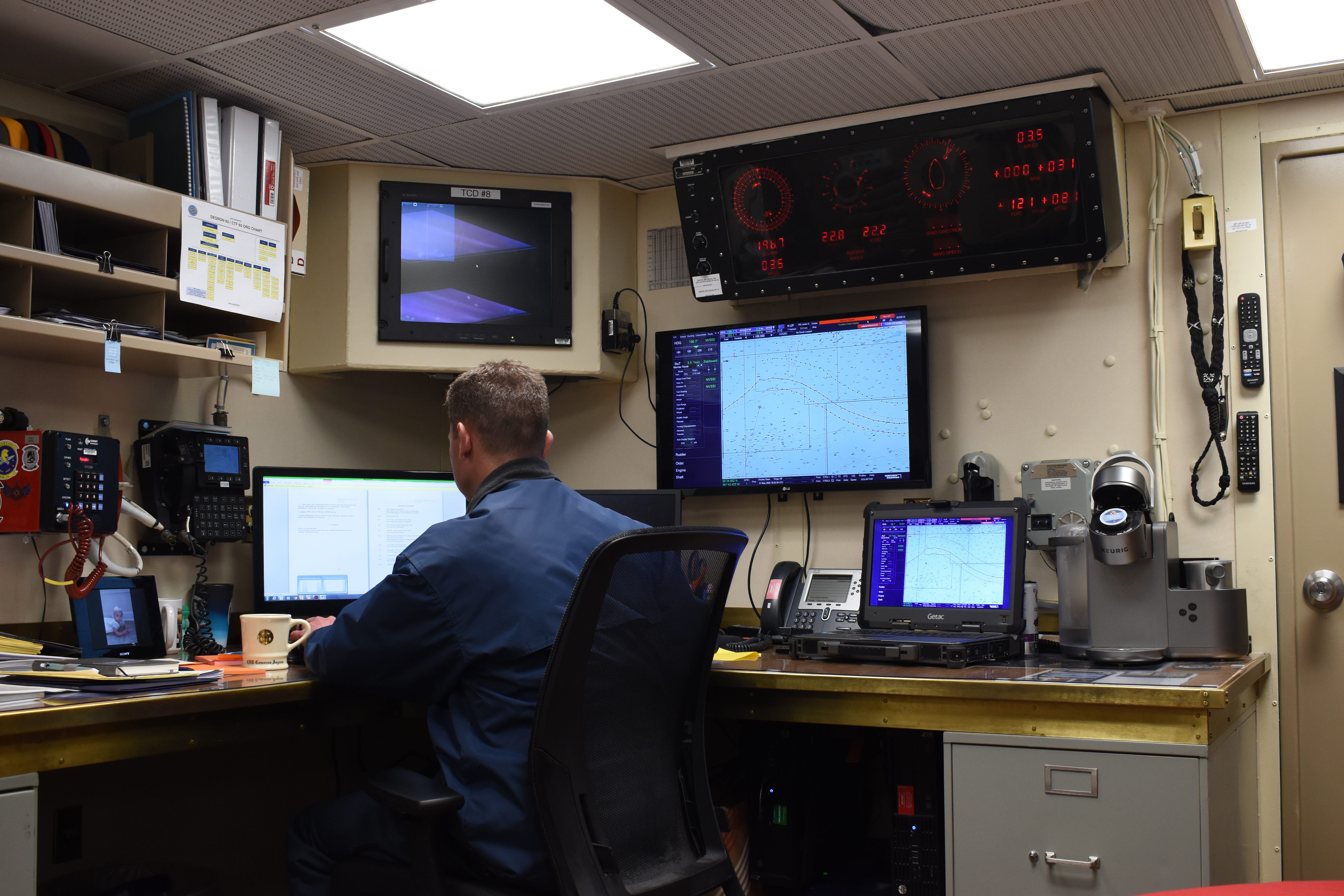 The captain of the Navy destroyer USS Thomas Hudner works in his space in May 2025.