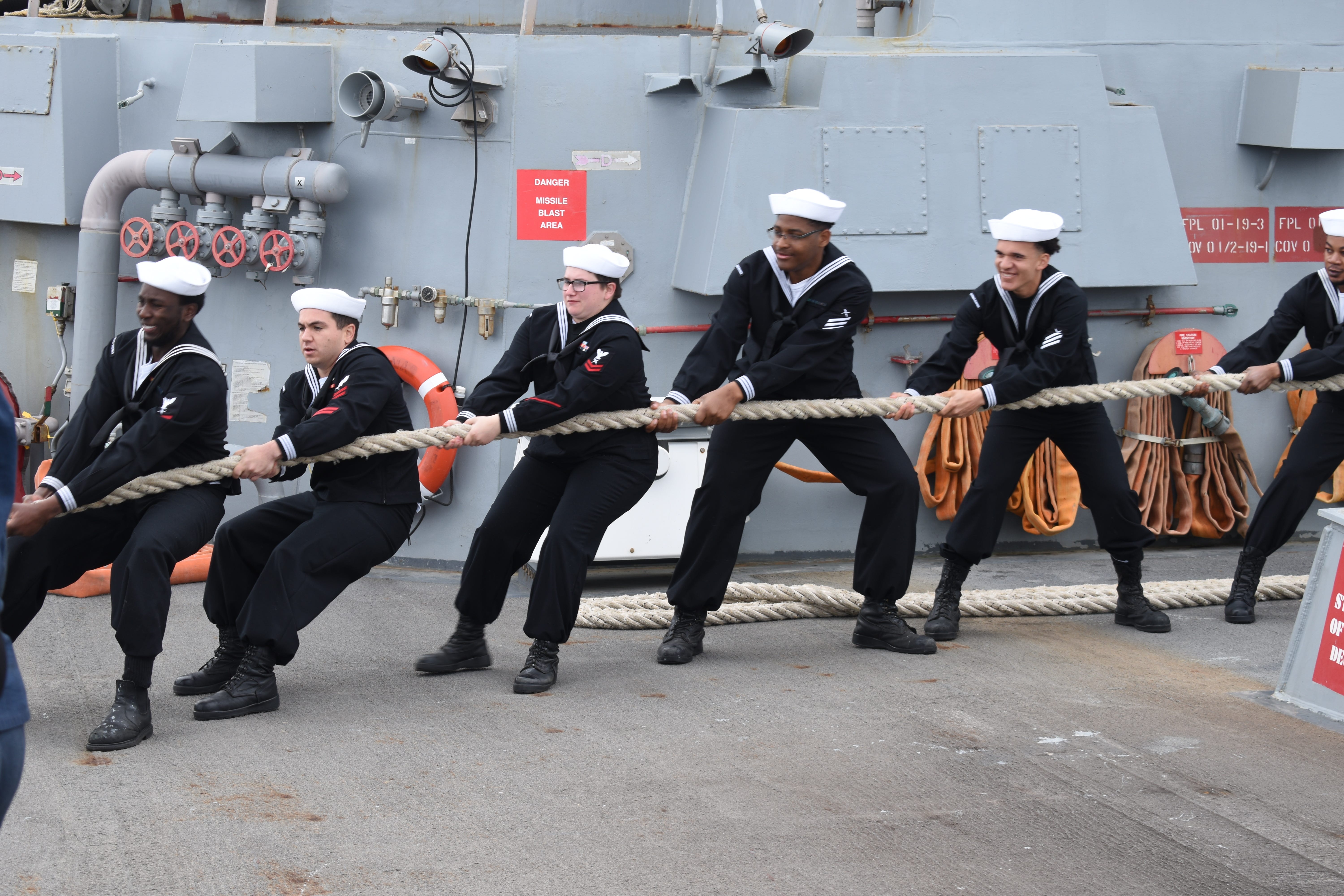 Sailors pull a rope aboard the Navy destroyer USS Thomas Hudner in June 2025.