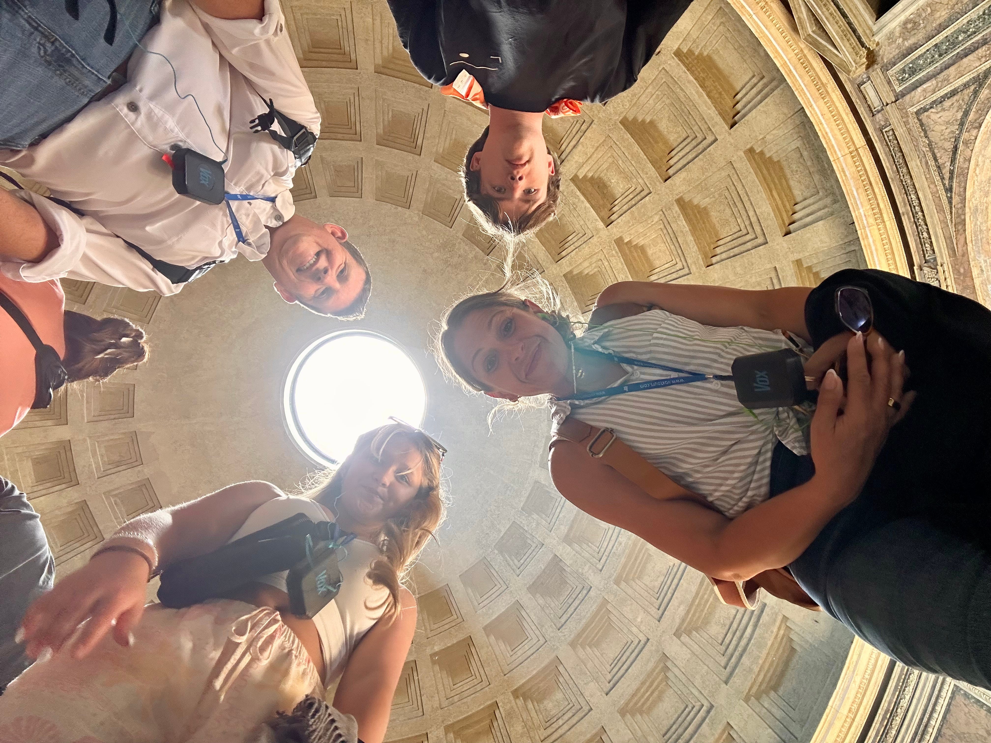 The author and her family looking down at the camera in the Pantheon in Rome. View from below, with the ceiling above.