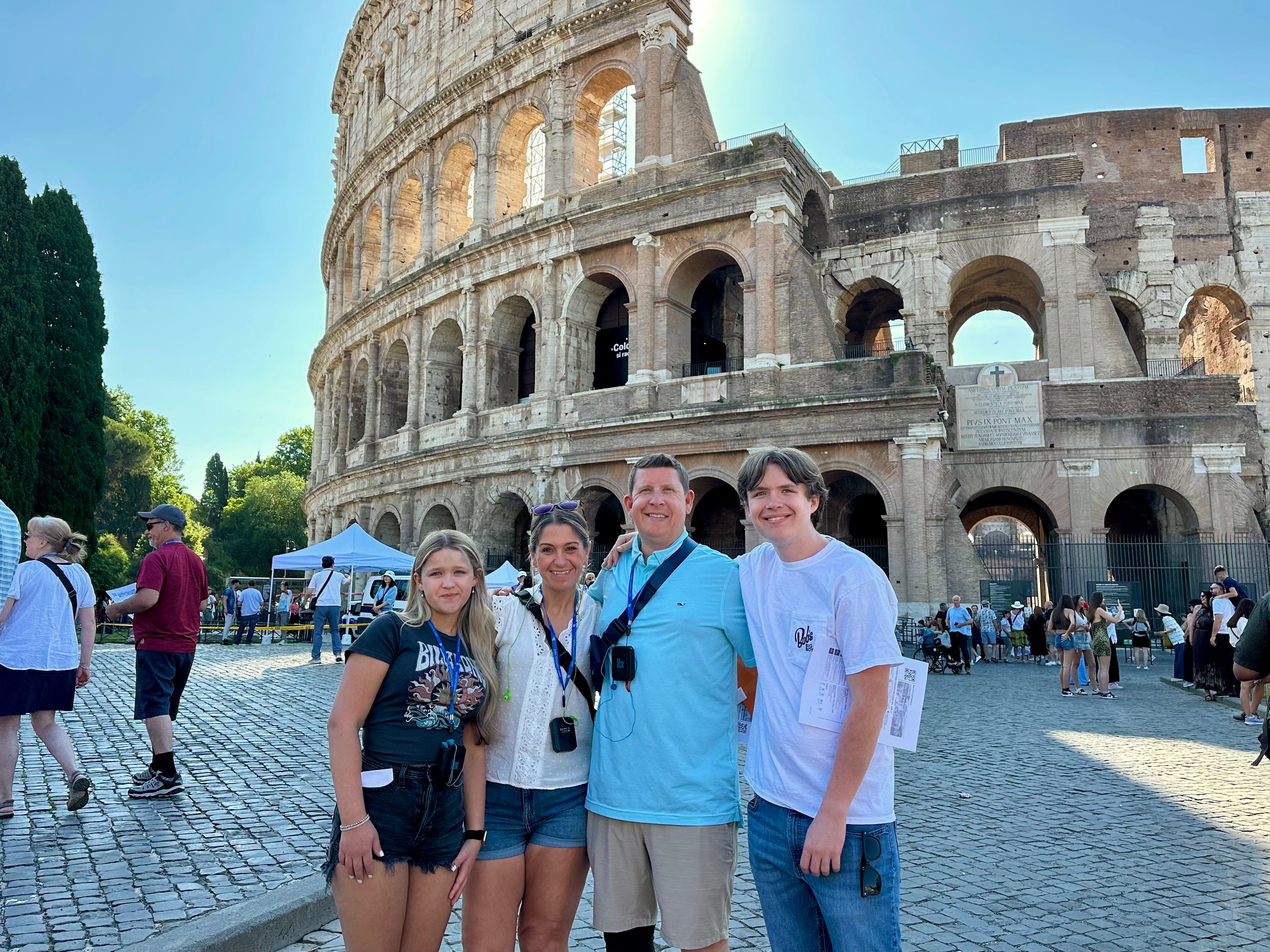 The author and her family standing in front of the Colosseum in Rome on a sunny day.