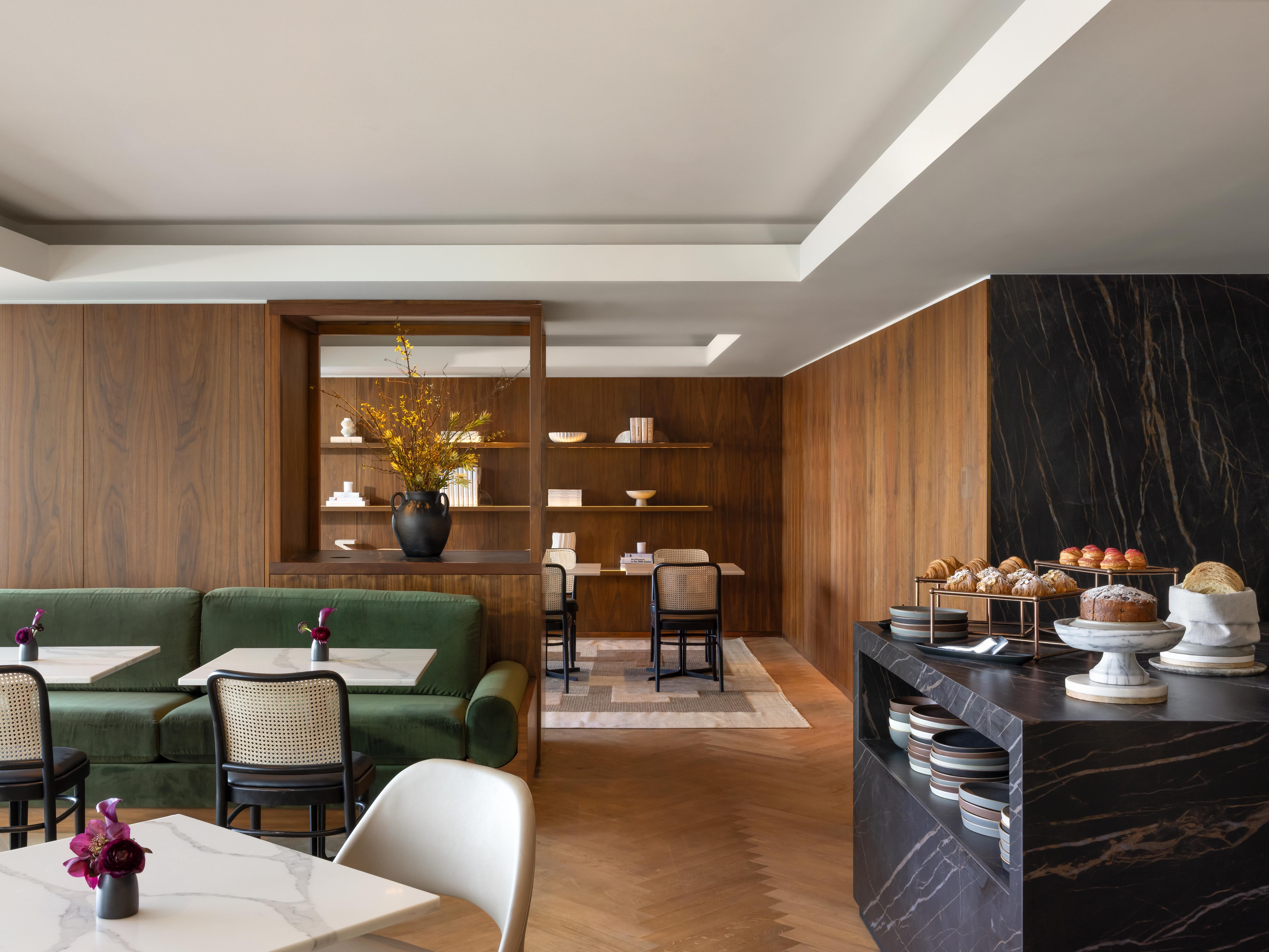 Seating on the left and a counter on the right topped with food inside the Gold lounge at the Fairmont Pacific Rim in Vancouver