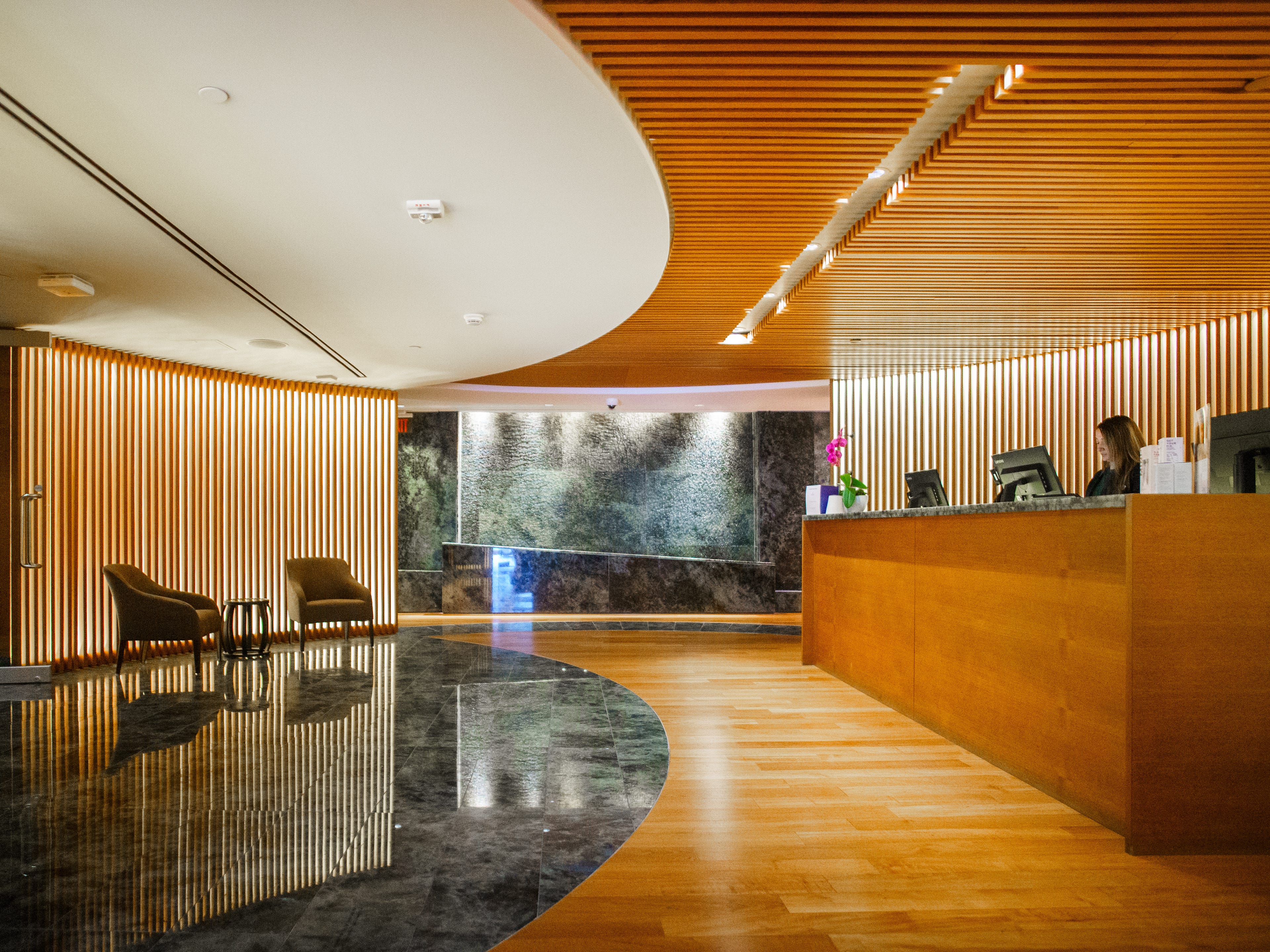A spa lobby with seating on the left, a check-in counter on the right, and a fountain in the middle