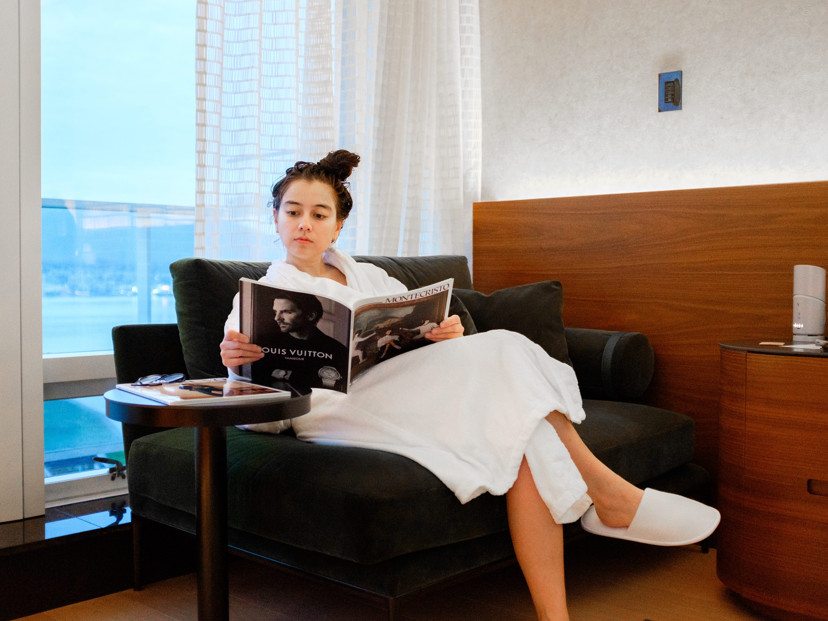 The author sits in a robe reading a magazine in a Gold room at the Fairmon Pacific Rim in Vancouver