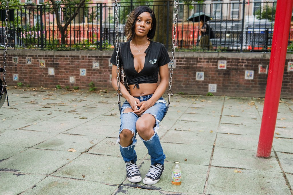 Woman sitting on a swing in a playground.