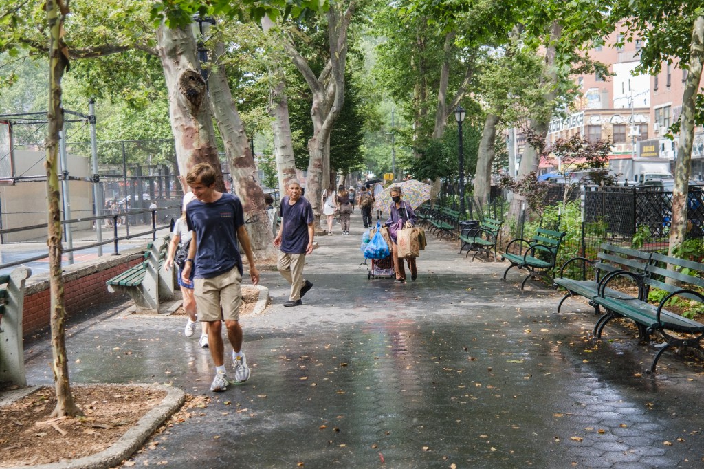People walking through a park on a rainy day.