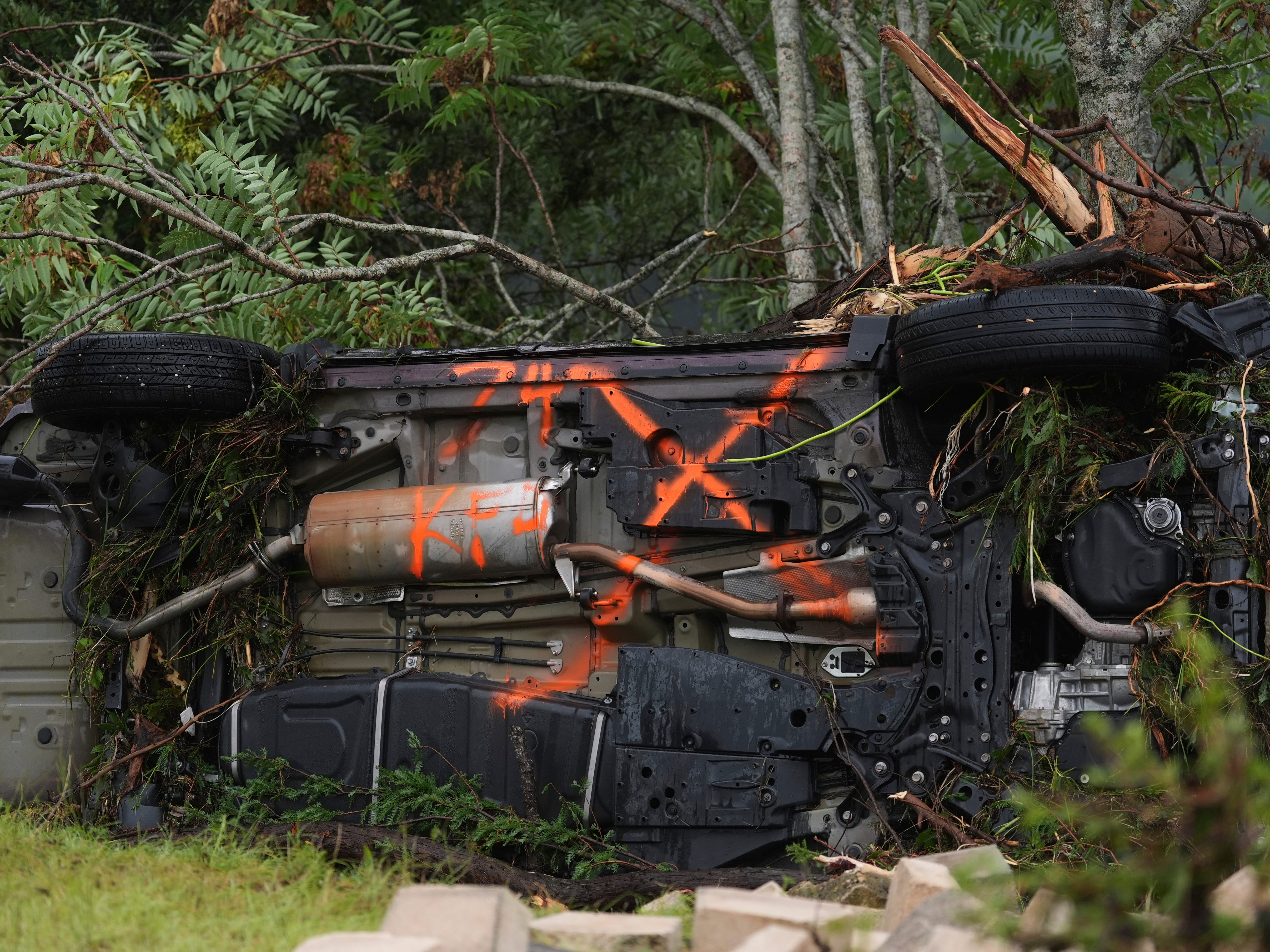 An overturned vehicle is caught in debris along the Guadalupe River after a flash flood struck the area, Friday, July 4, 2025, in Kerrville, Texas.
