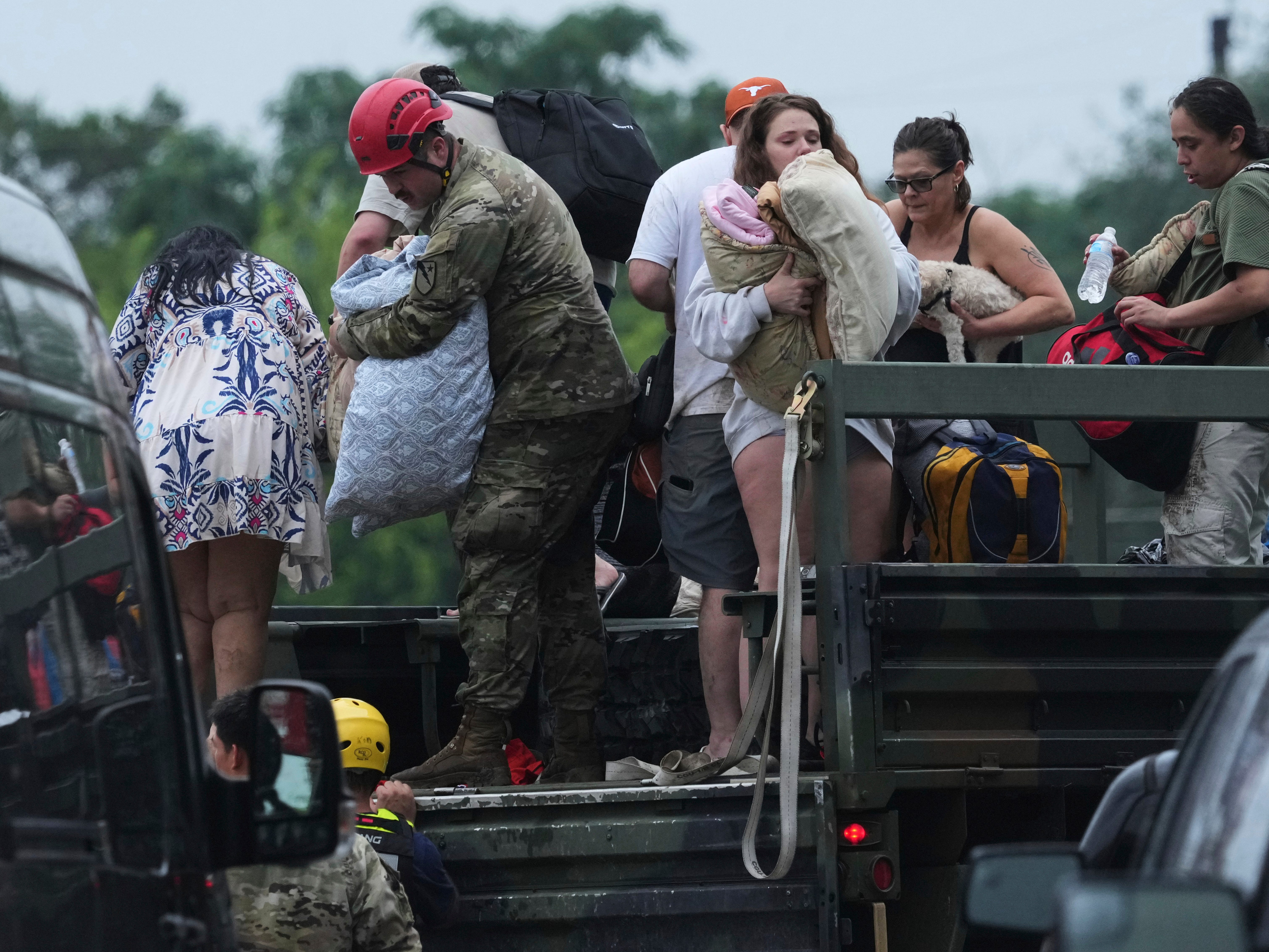 First responders deliver people to a reunification center after flash flooding in the area, Friday, July 4, 2025, in Ingram, Texas.