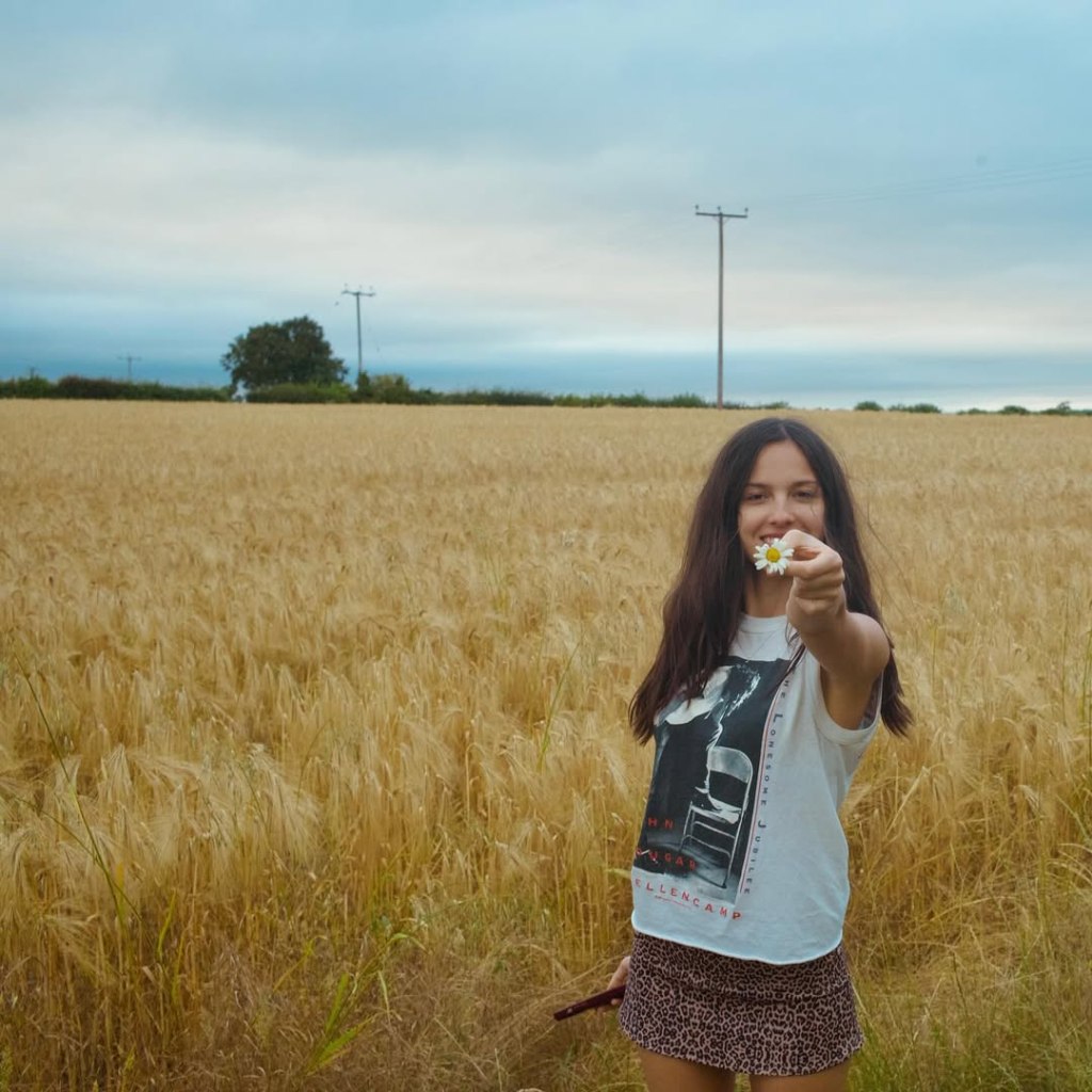 Olivia Rodrigo takes some time to pick the flowers after performing at Glastonbury.