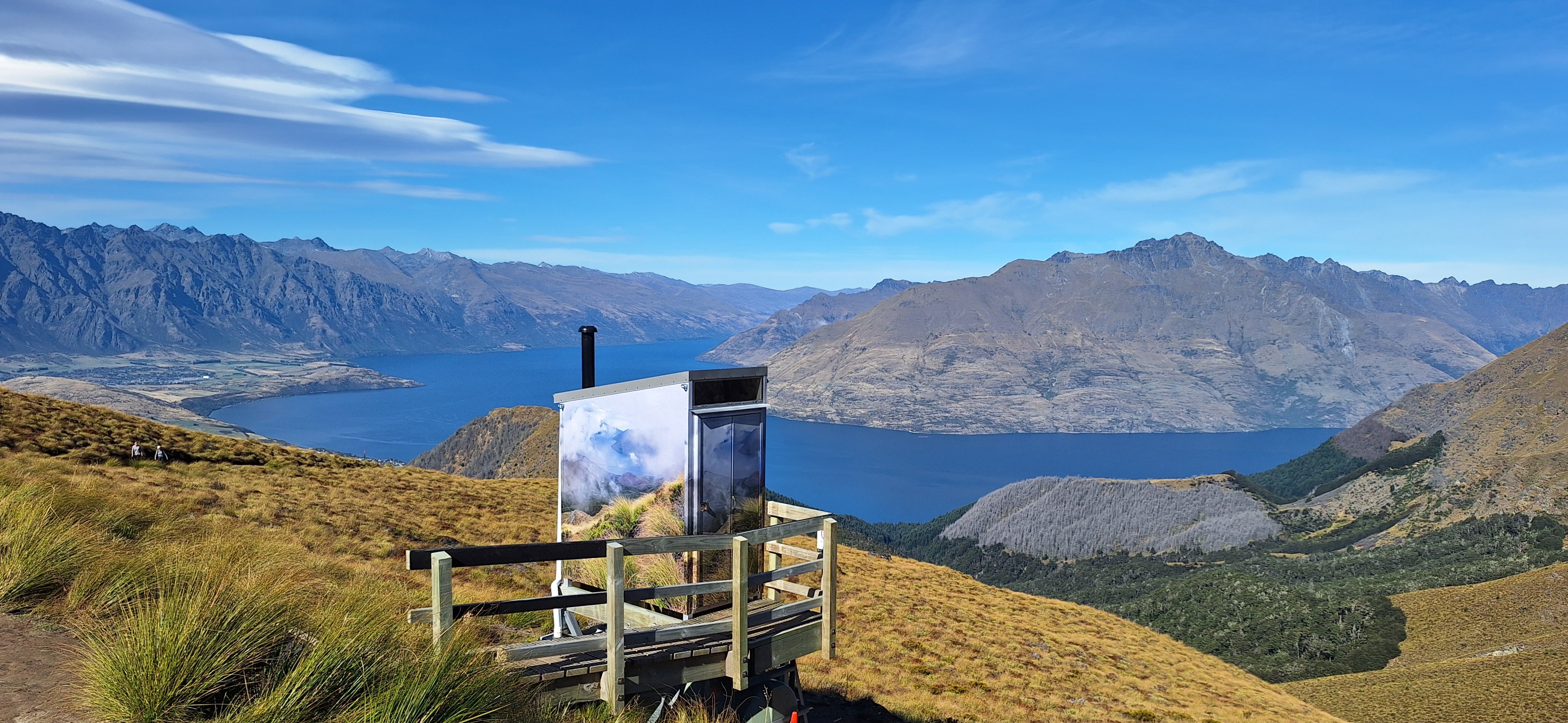 An image of mountains with water surrounding them and a small shedlike stucture