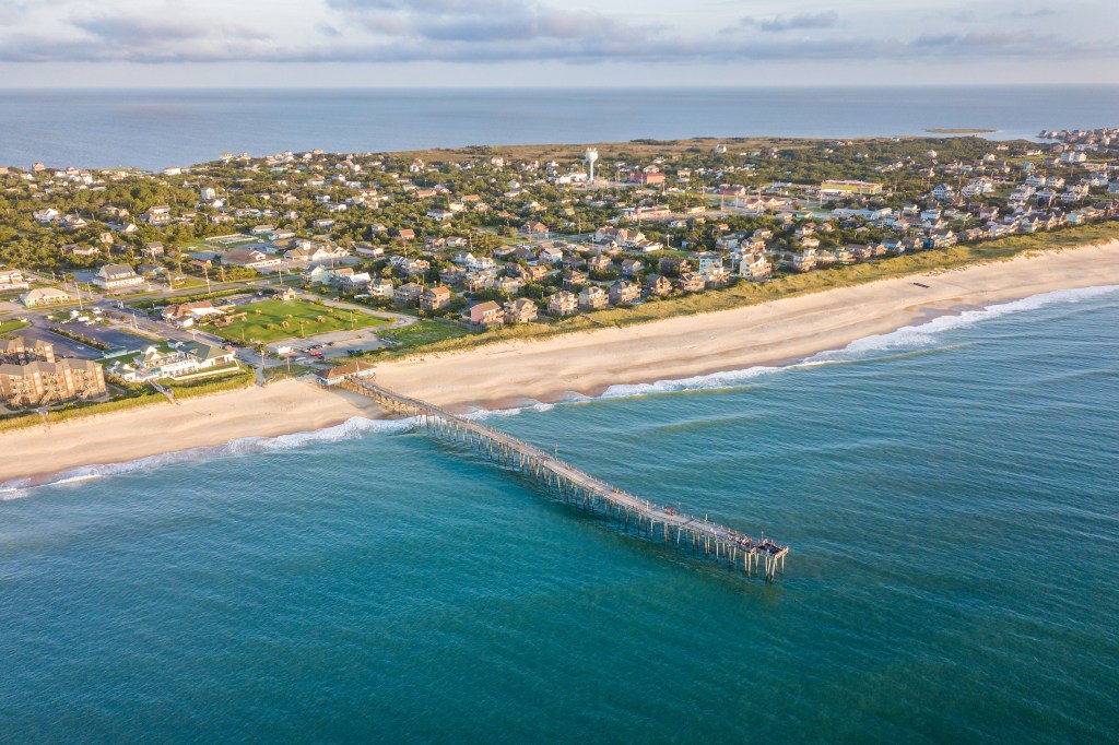Aerial view of Outer Banks, North Carolina, showing a pier extending into the ocean.