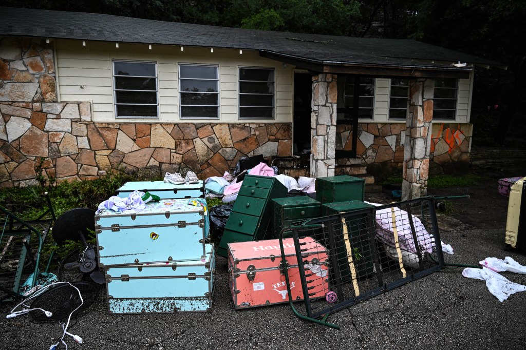 Water-damaged belongings outside a cabin after flooding.