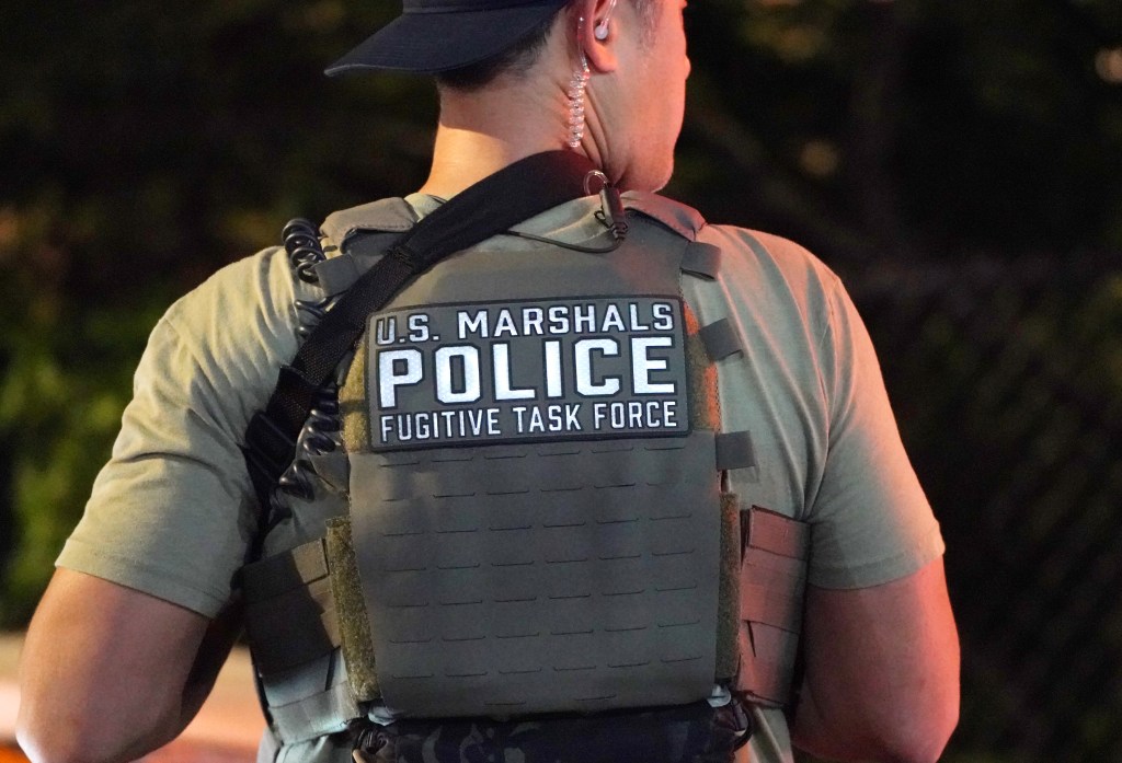 U.S. Marshals Police Fugitive Task Force officer's back.