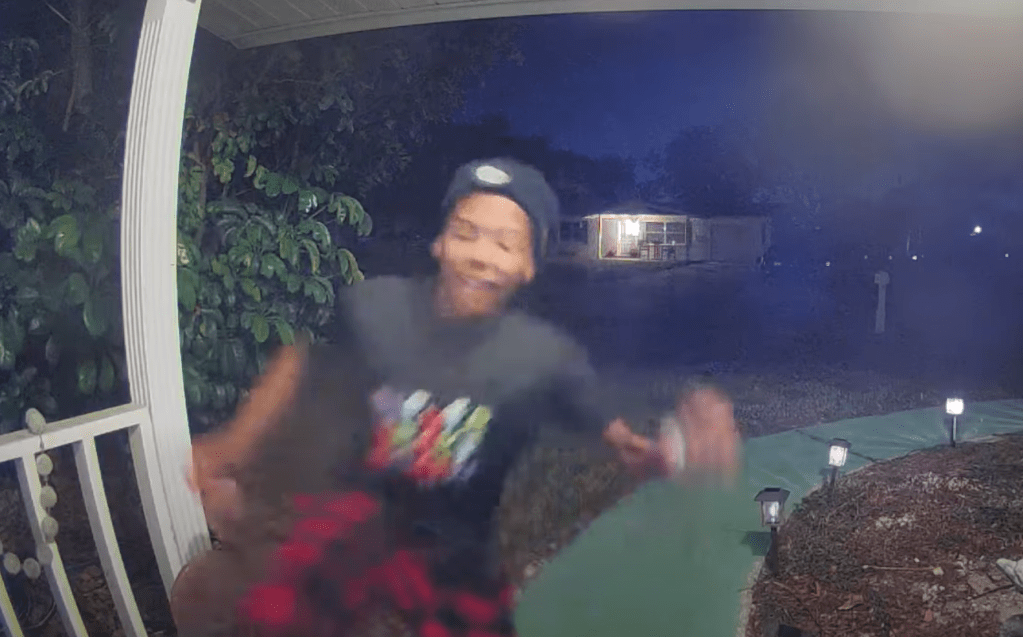 Security camera footage of a person at night.