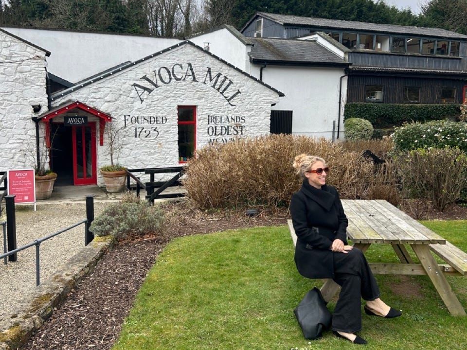 Author Alesandra Dubin sitting at a picnic table outside of a building