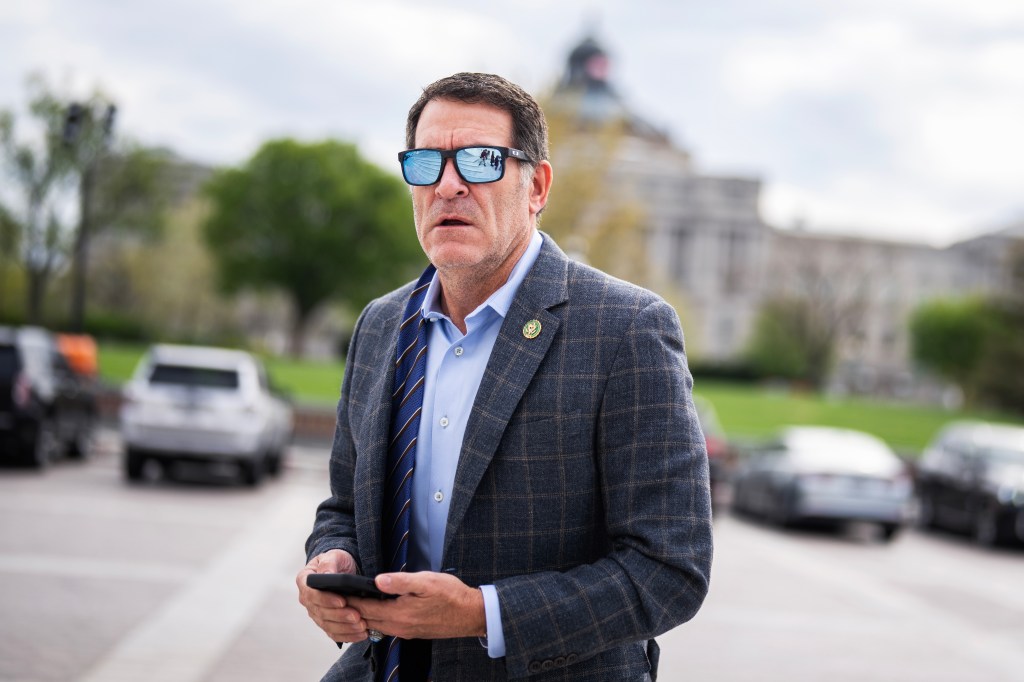 Rep. Mark Green looking at his phone outside the U.S. Capitol.