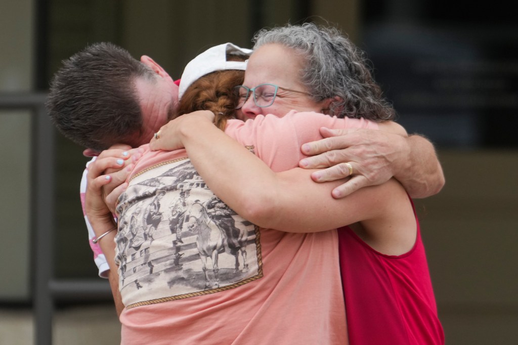 Family embracing after heavy rainfall in Central Texas.