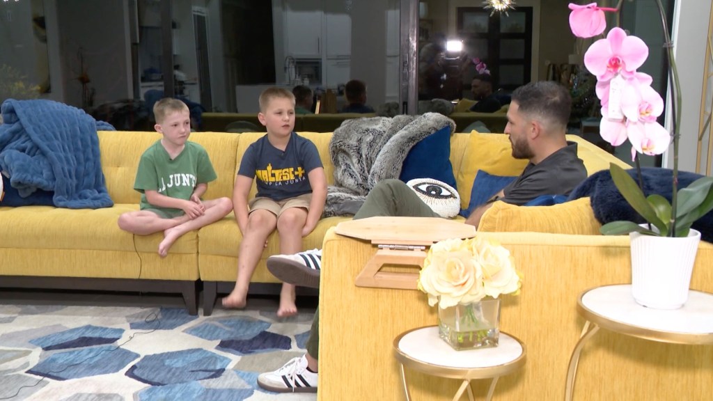 Two brothers being interviewed on a yellow couch.