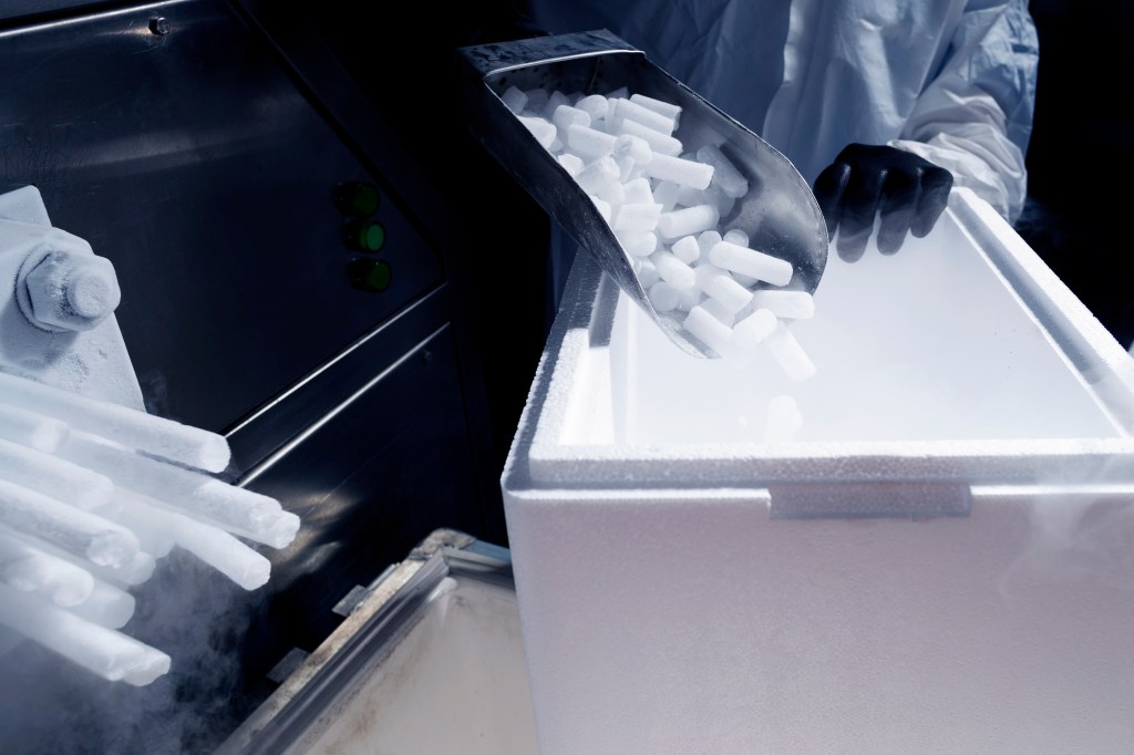Dry ice being scooped into a container.