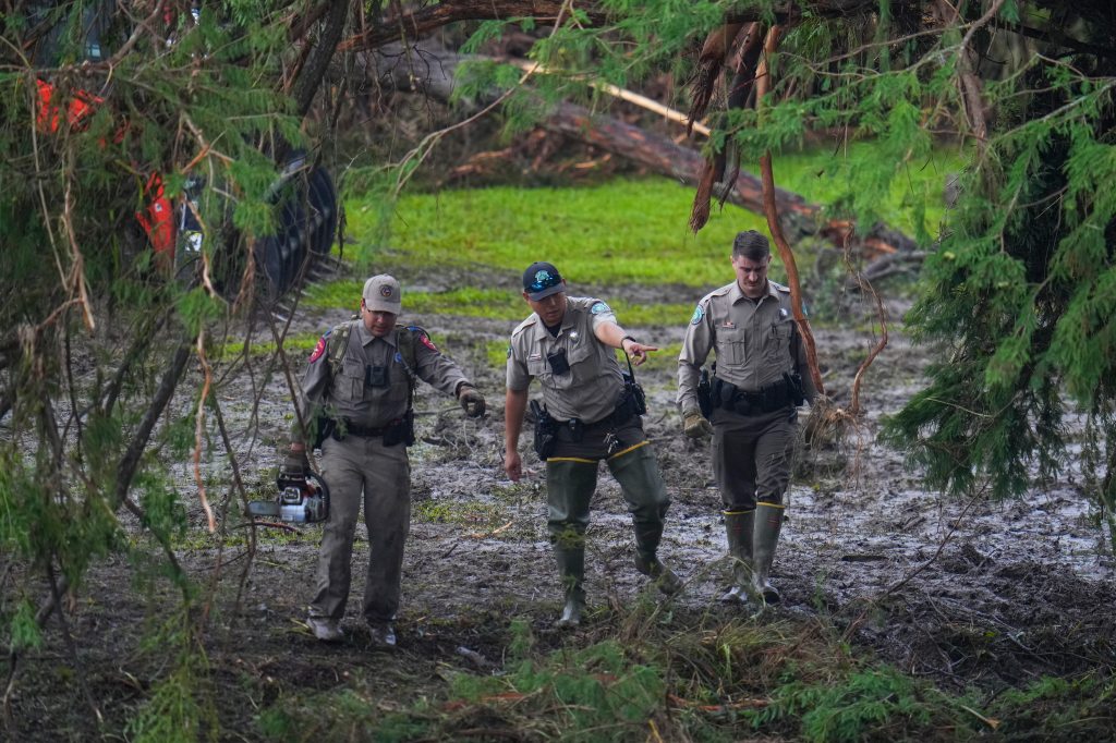 Three officials surveying flood damage.