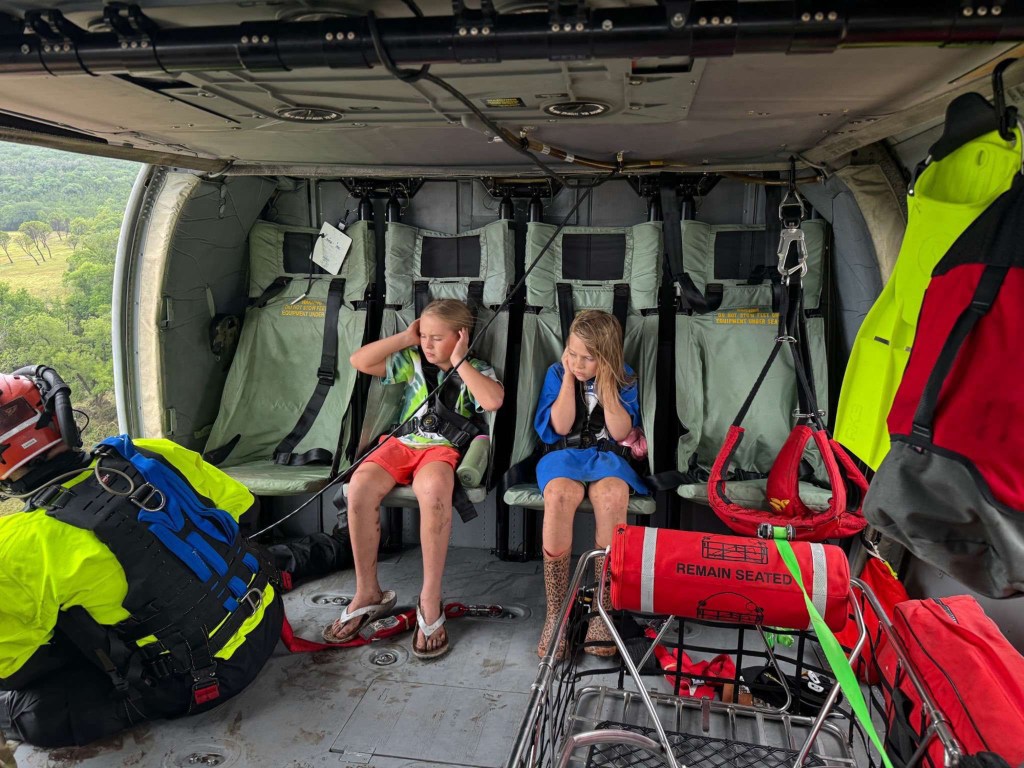 Two girls getting rescued from the floodwaters in Texas by a helicopter.