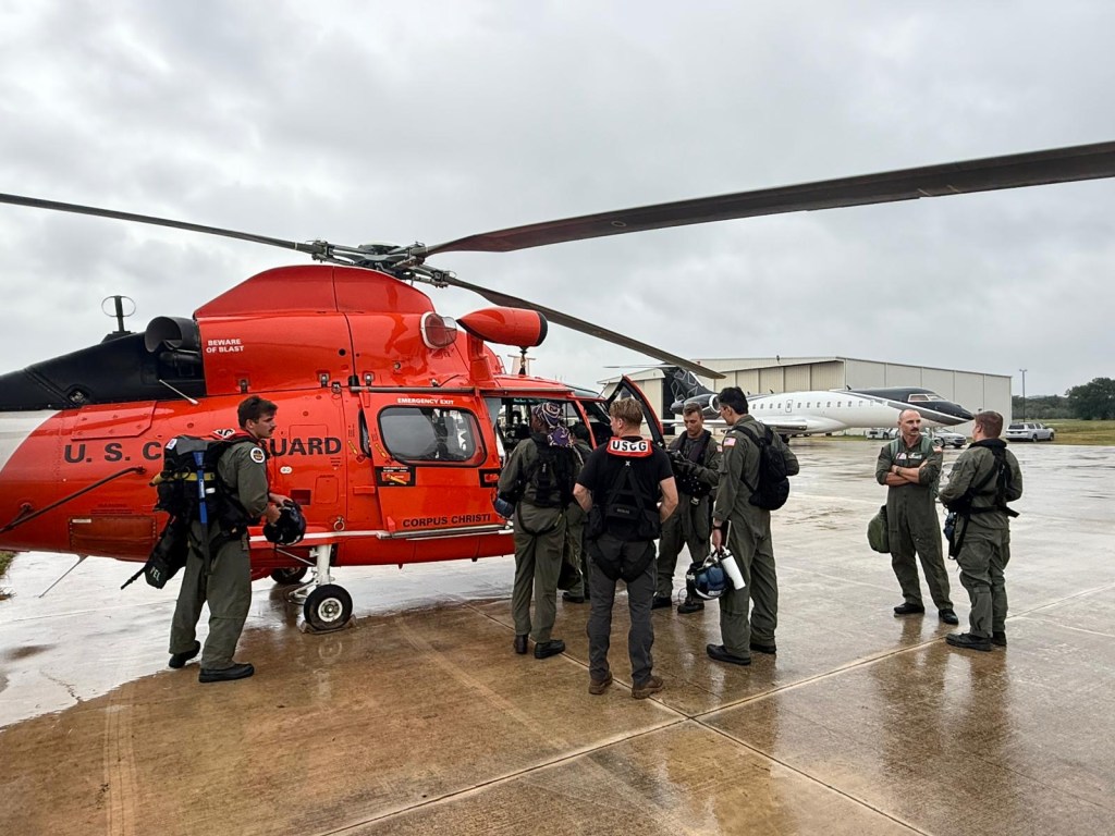 A Coast Guard crew participating in rescue missions near Kerrville, Texas with a MH-65 helicopter.