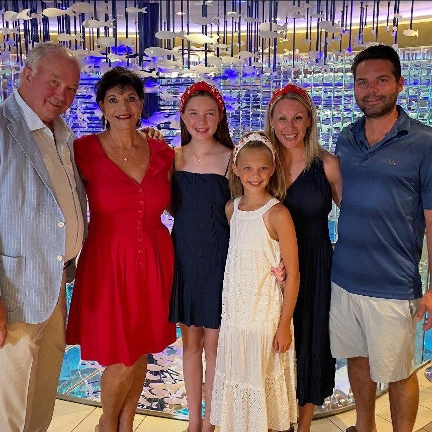 Family posing for a photo in front of a fish sculpture.