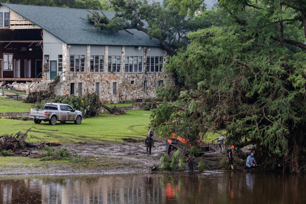 Search and recovery workers at flood-damaged building.