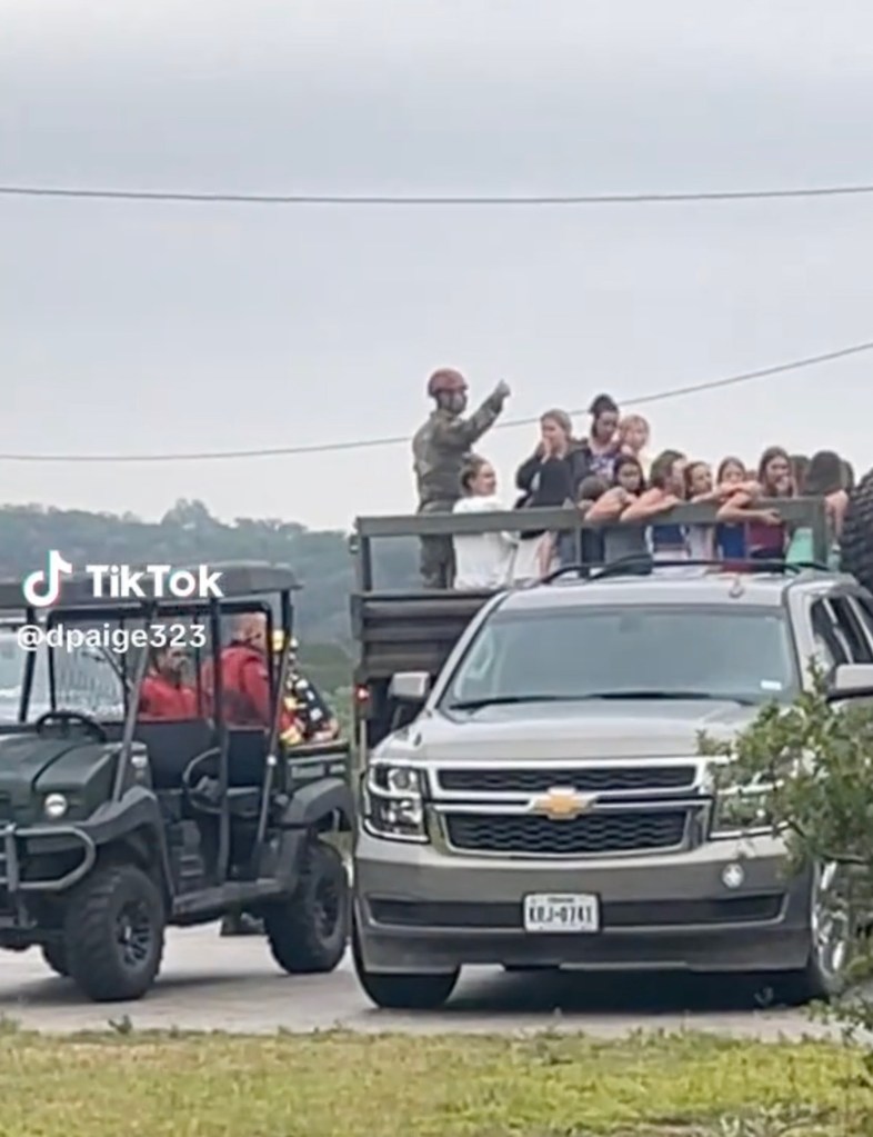 Flood evacuees in Texas being transported on the back of a truck.