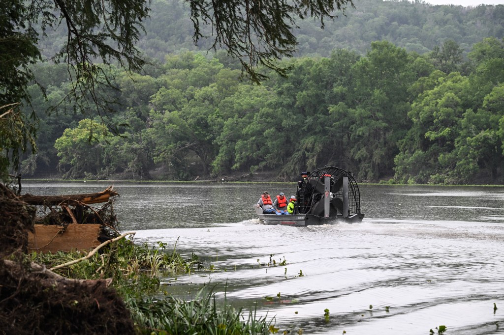 Airboat search and rescue team on flooded river.