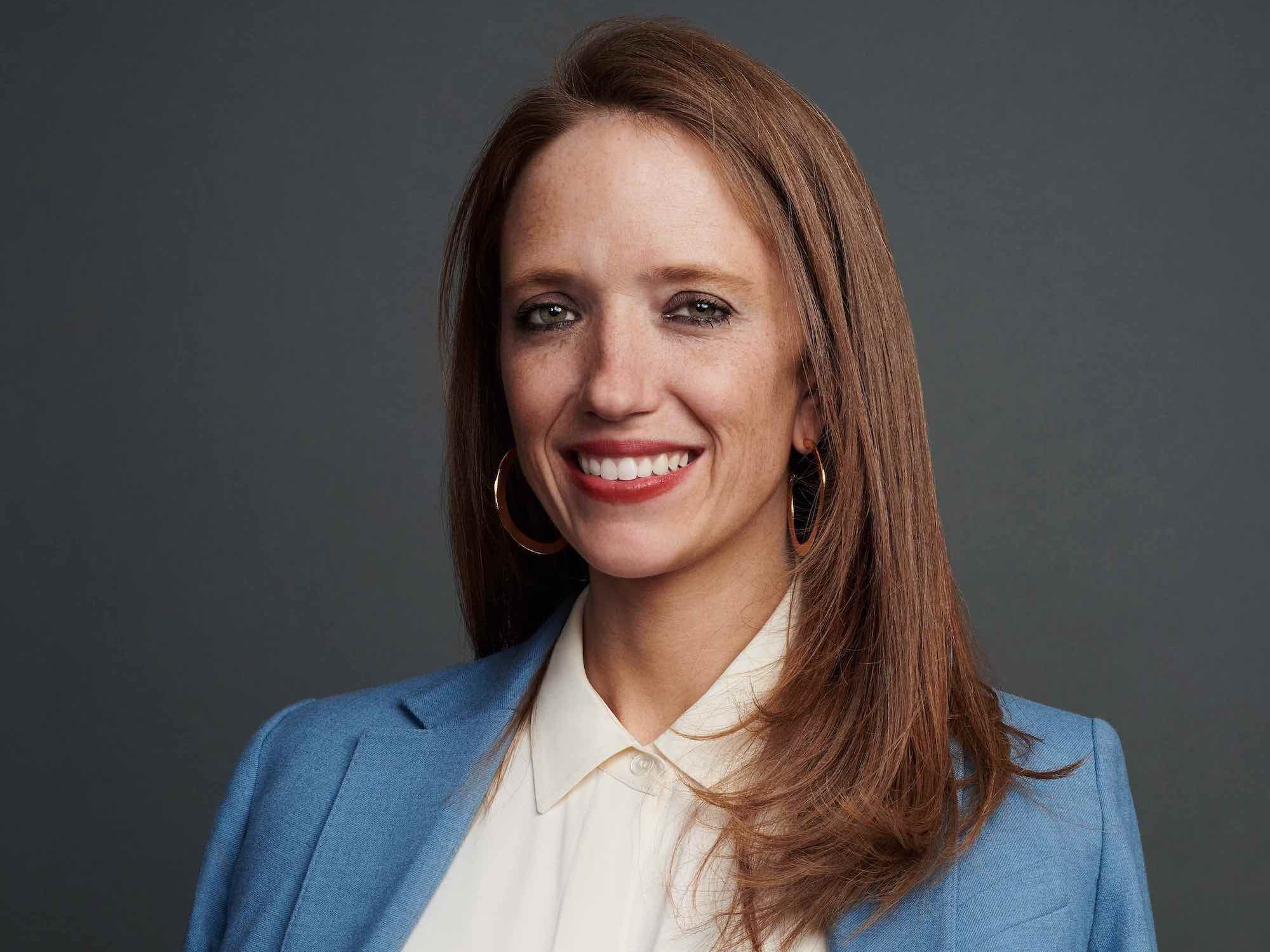 Maven founder and CEO Kate Ryder poses for a photo against a gray background.