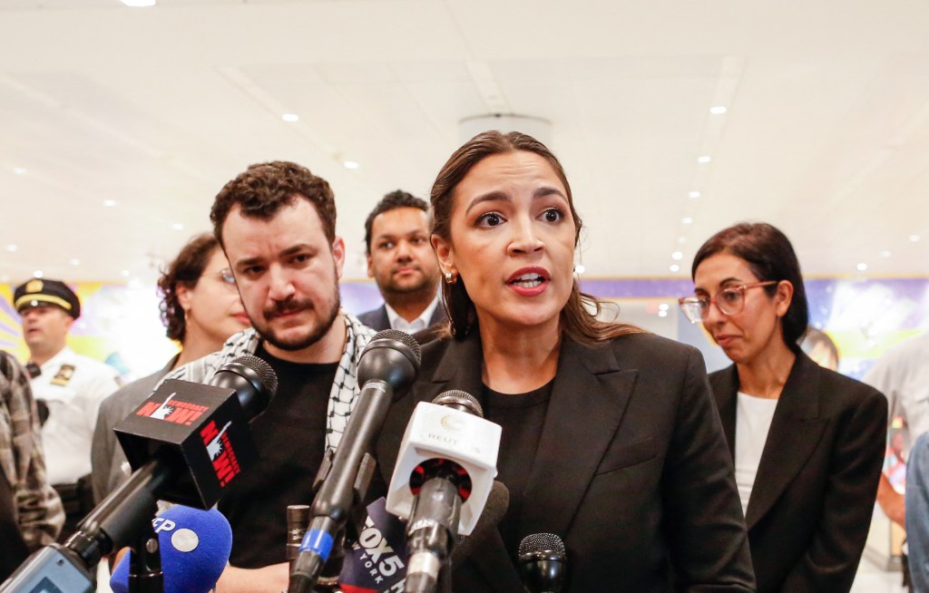 Rep. Alexandria Ocasio-Cortez speaks to reporters alongside Mahmoud Khalil at Newark airport.