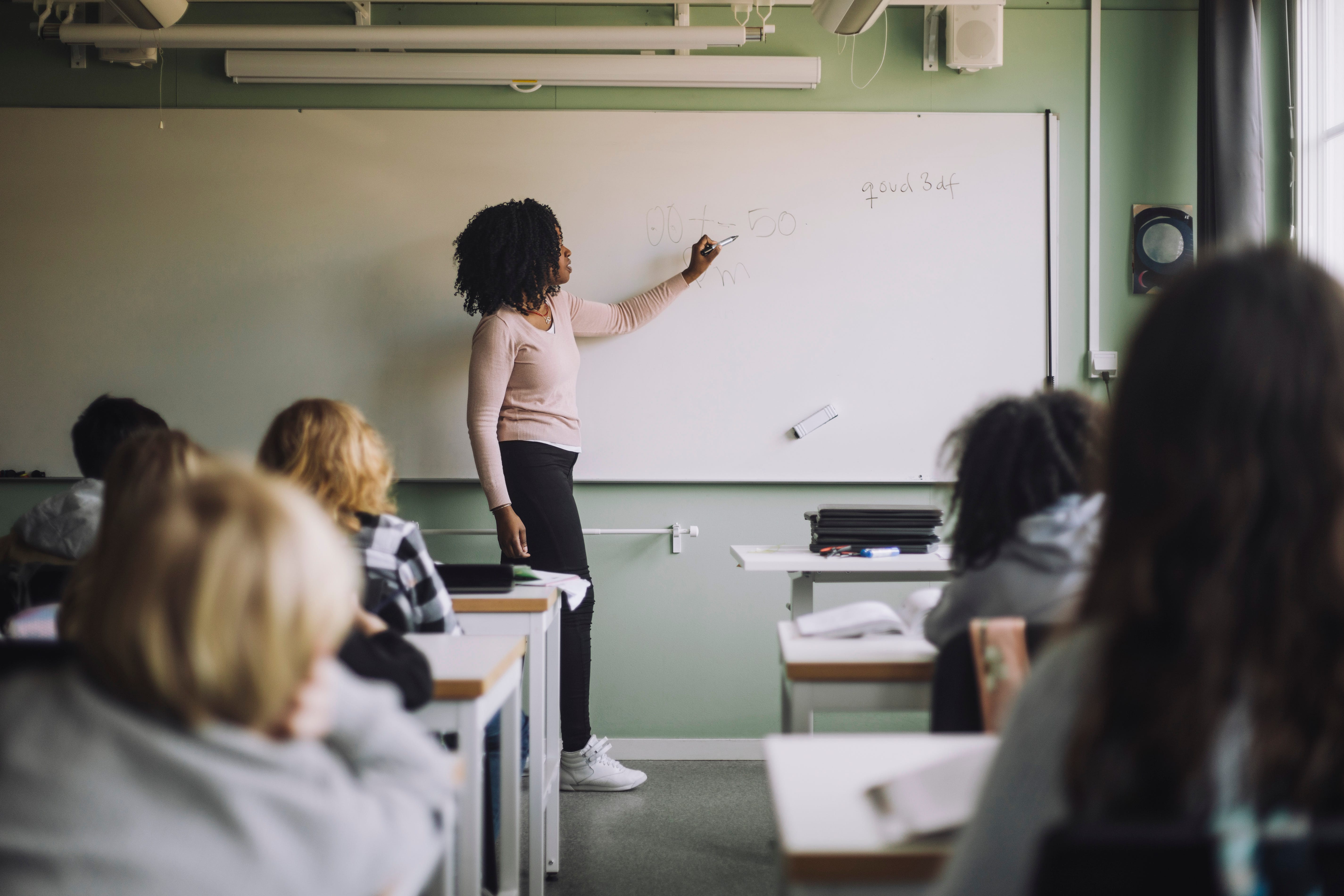 A t
eacher writing on a blackboard,