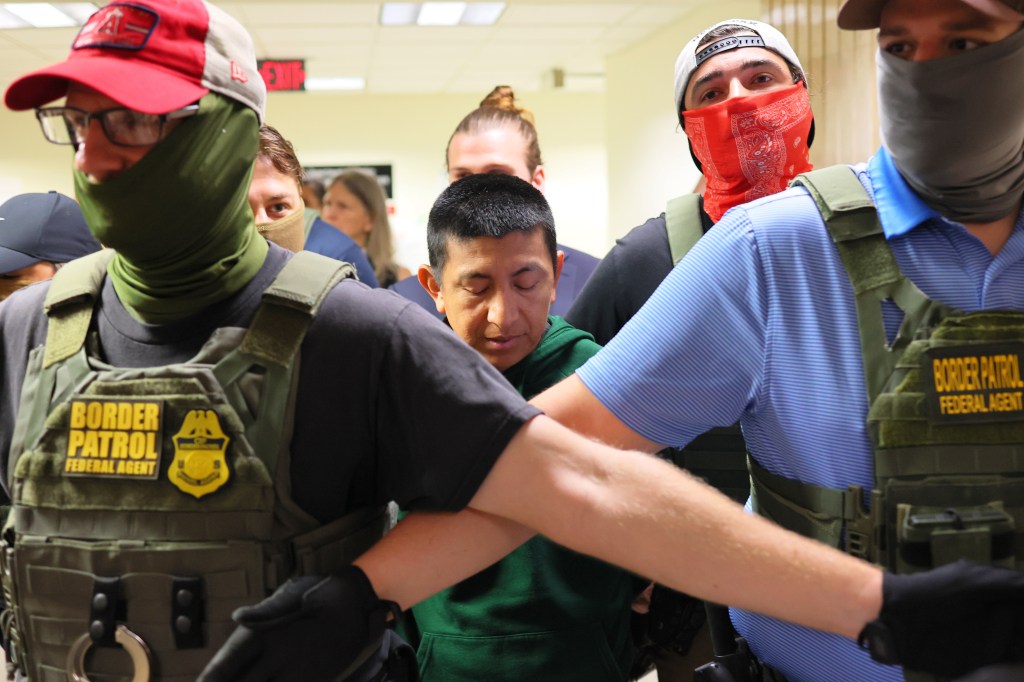 ICE agents detaining an immigrant inside a New York City courthouse.