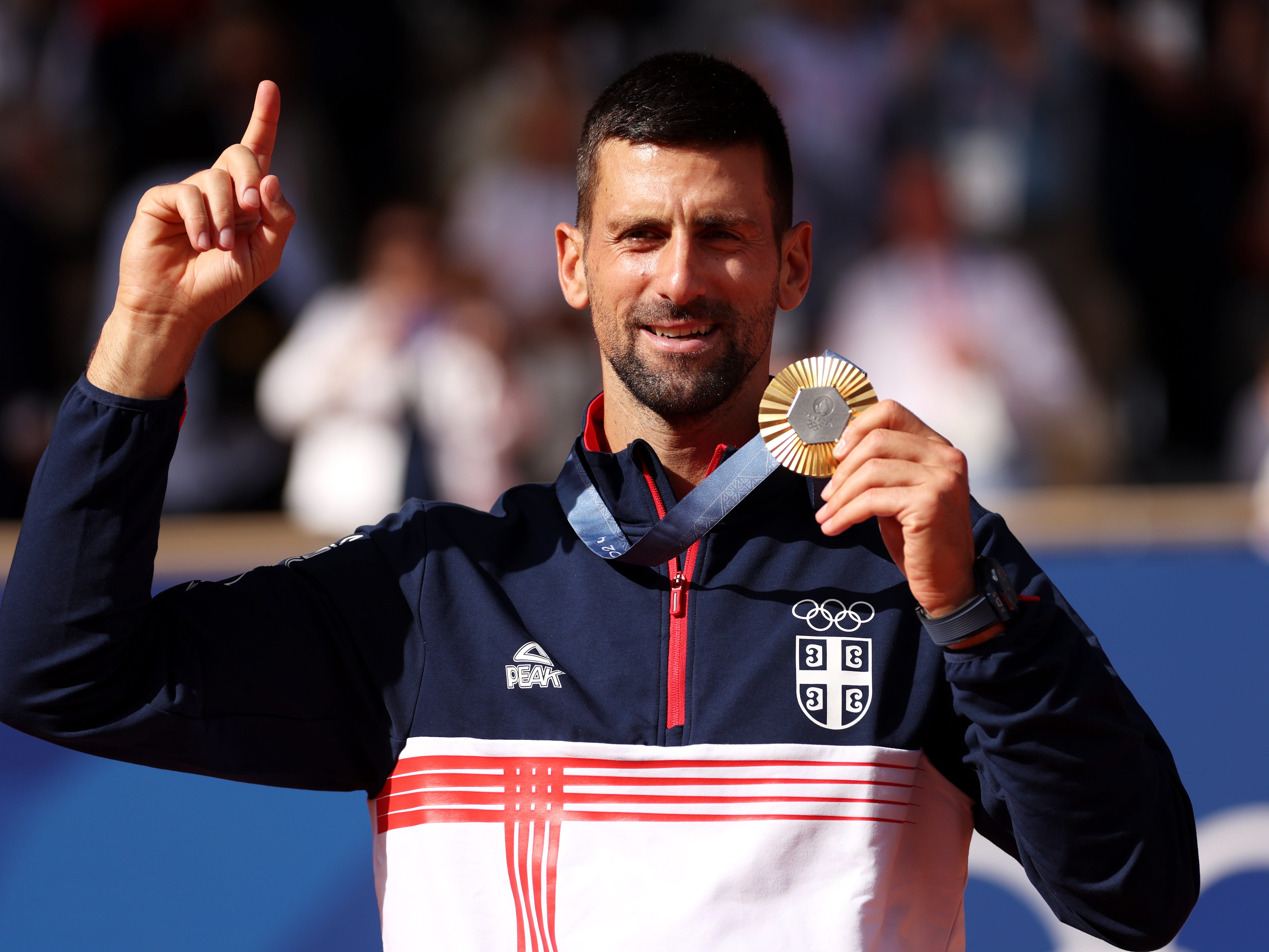 Gold medalist Novak Djokovic of Team Serbia celebrates on the podium during the Tennis Men's Singles medal ceremony after the Tennis Men's Singles Gold medal match on day nine of the Olympic Games Paris 2024 at Roland Garros on August 04, 2024 in Paris, France.