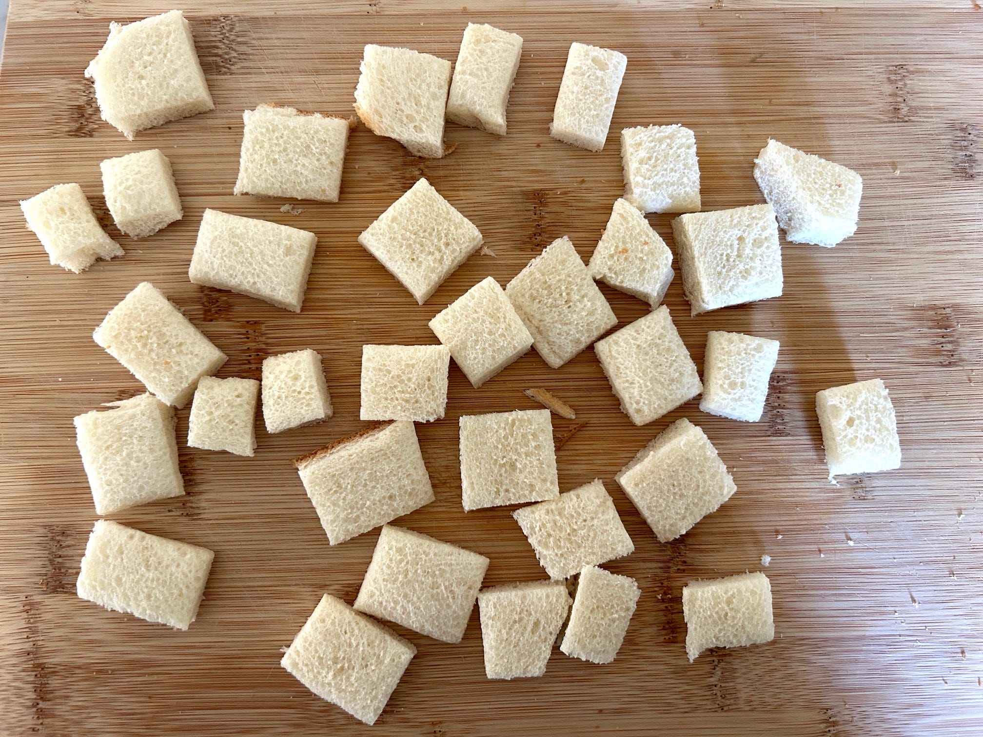 Cutting handmade croutons for Ina Garten's Greek panzanella salad
