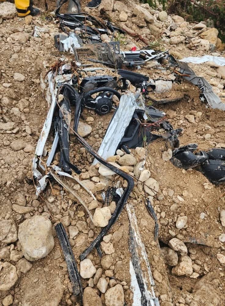 Wreckage of a vehicle in flood debris.